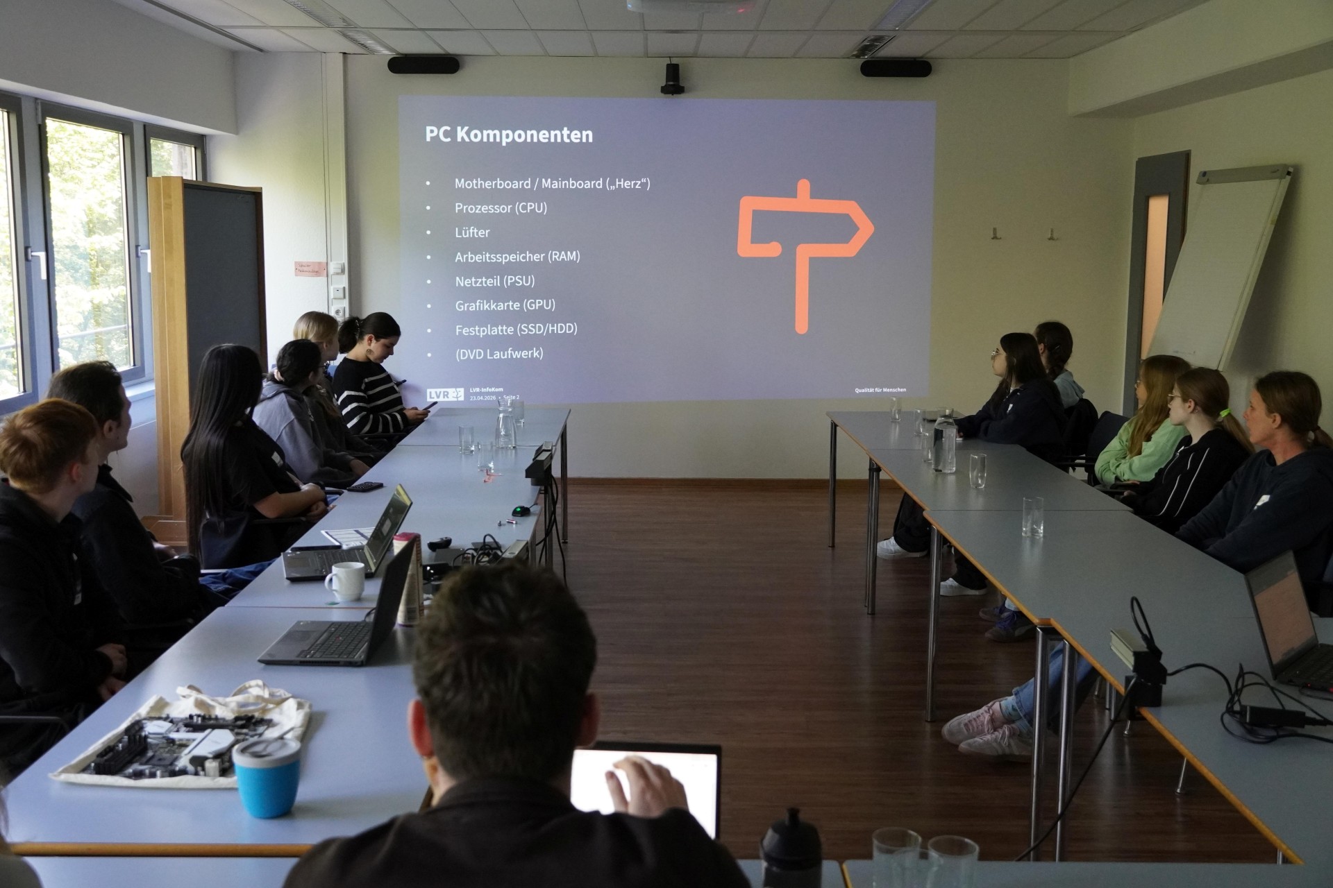 In einem Besprechungsraum schaut eine Gruppe von Mädchen auf eine Präsentation über IT-Technik.
