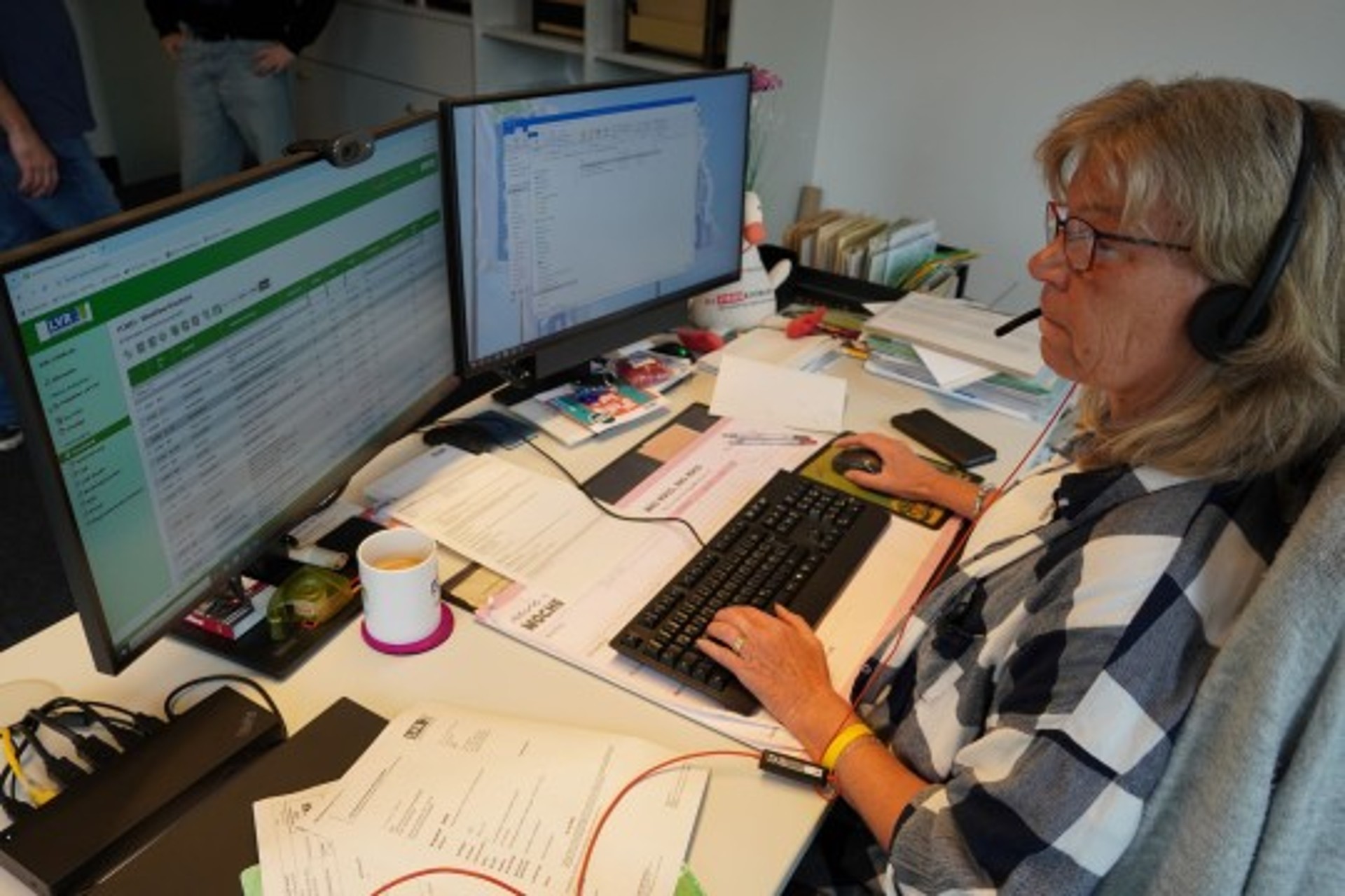 Eine Frau mit Headset sitzt vor einem Computer