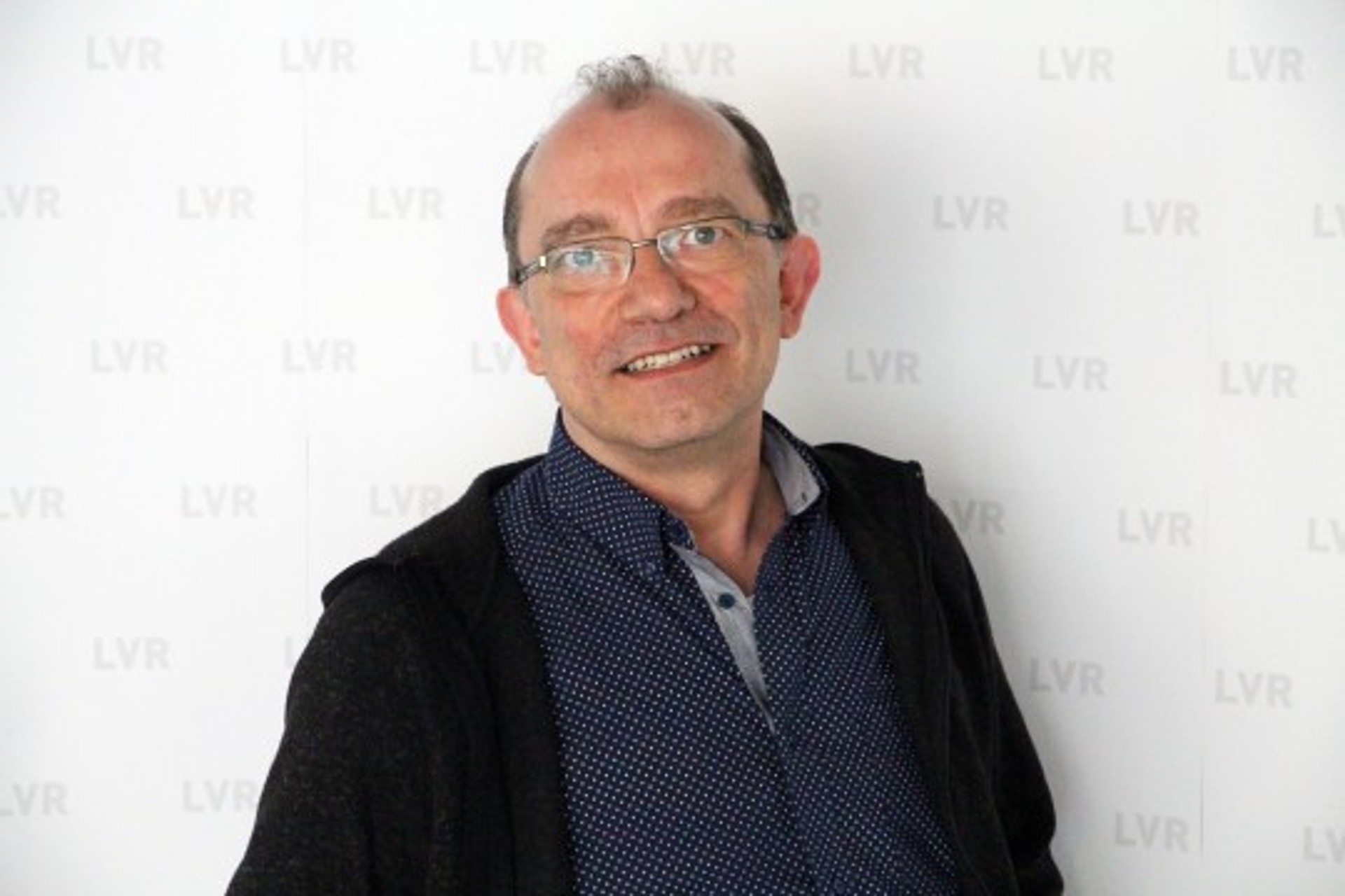 Ein Mann mit Brille lächelt in die Kamera