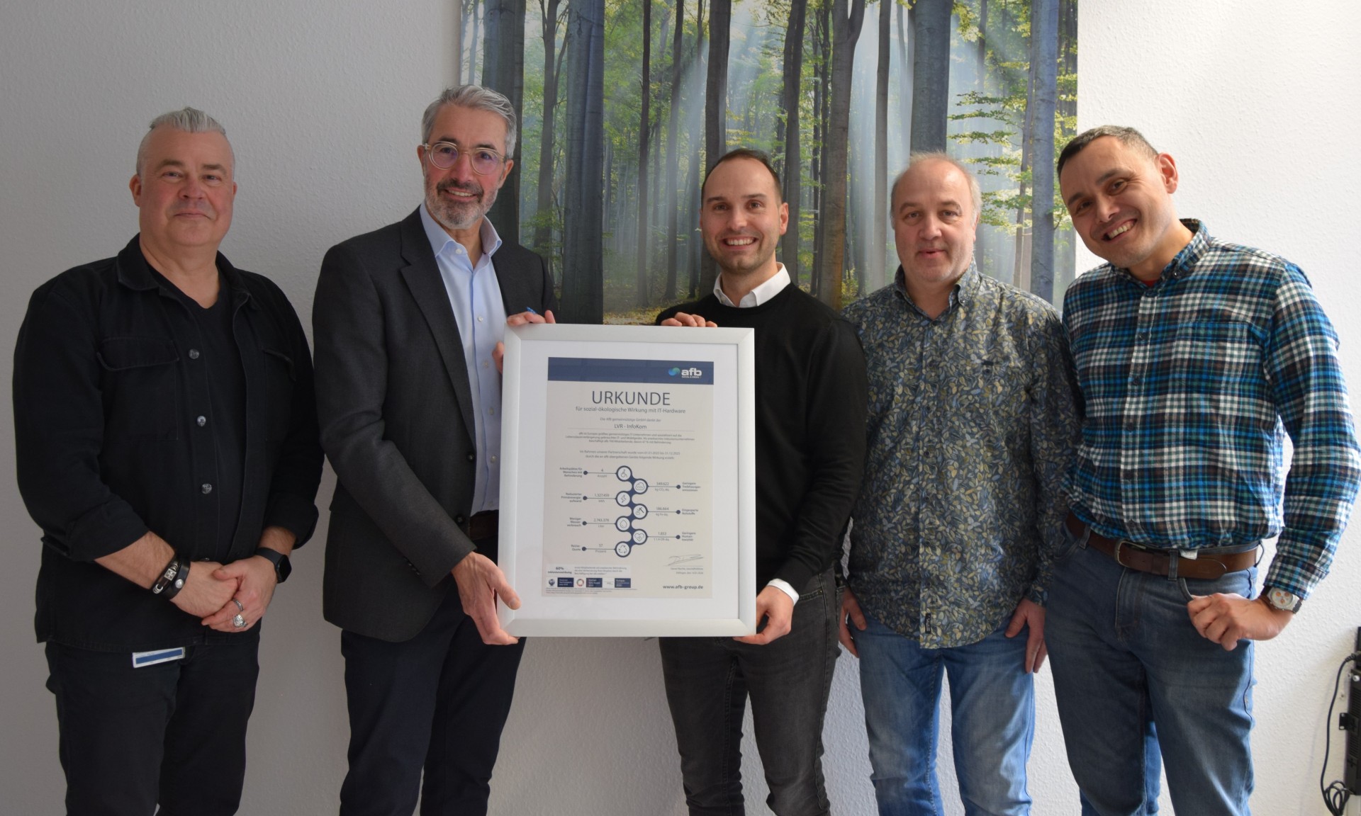 Im Bild sind fünf Personen bei der Übergabe der AfB-Wirkungsurkunde zu sehen. 