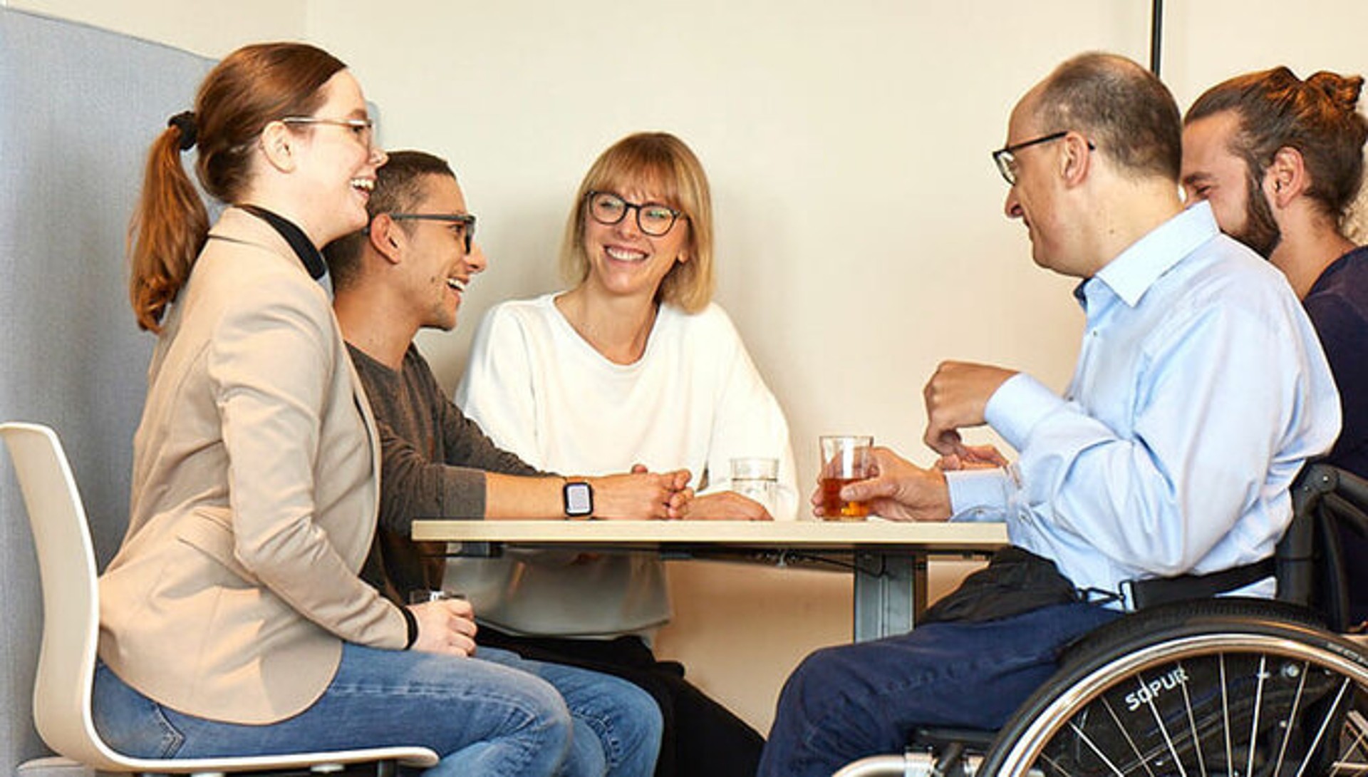Menschen sitzen um einen Tisch