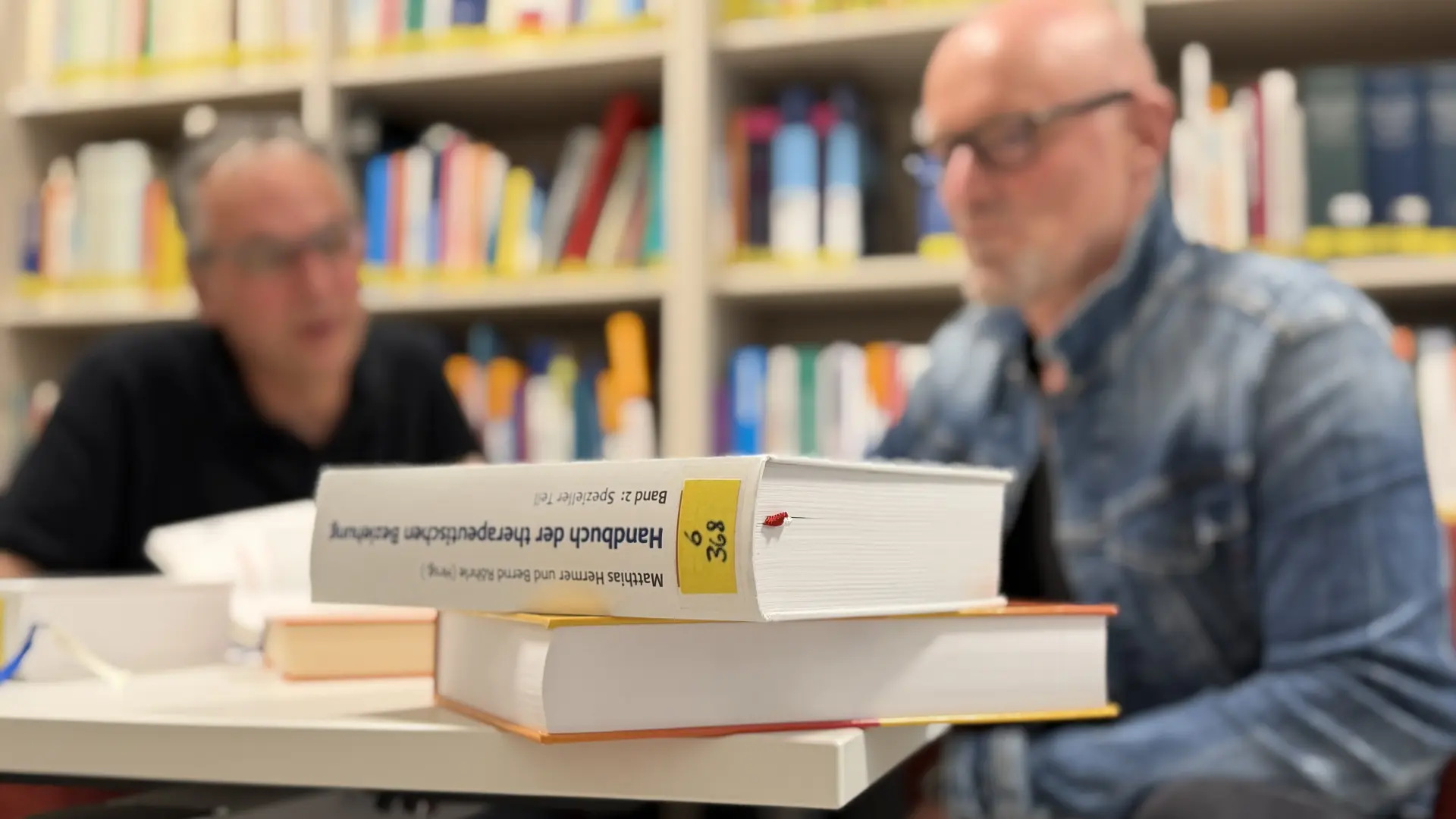 Mehrere Personen legen ihre Hände und Arme übereinander und bilden so symbolisch ein Zeichen für Zusammenhalt und Teamarbeit.