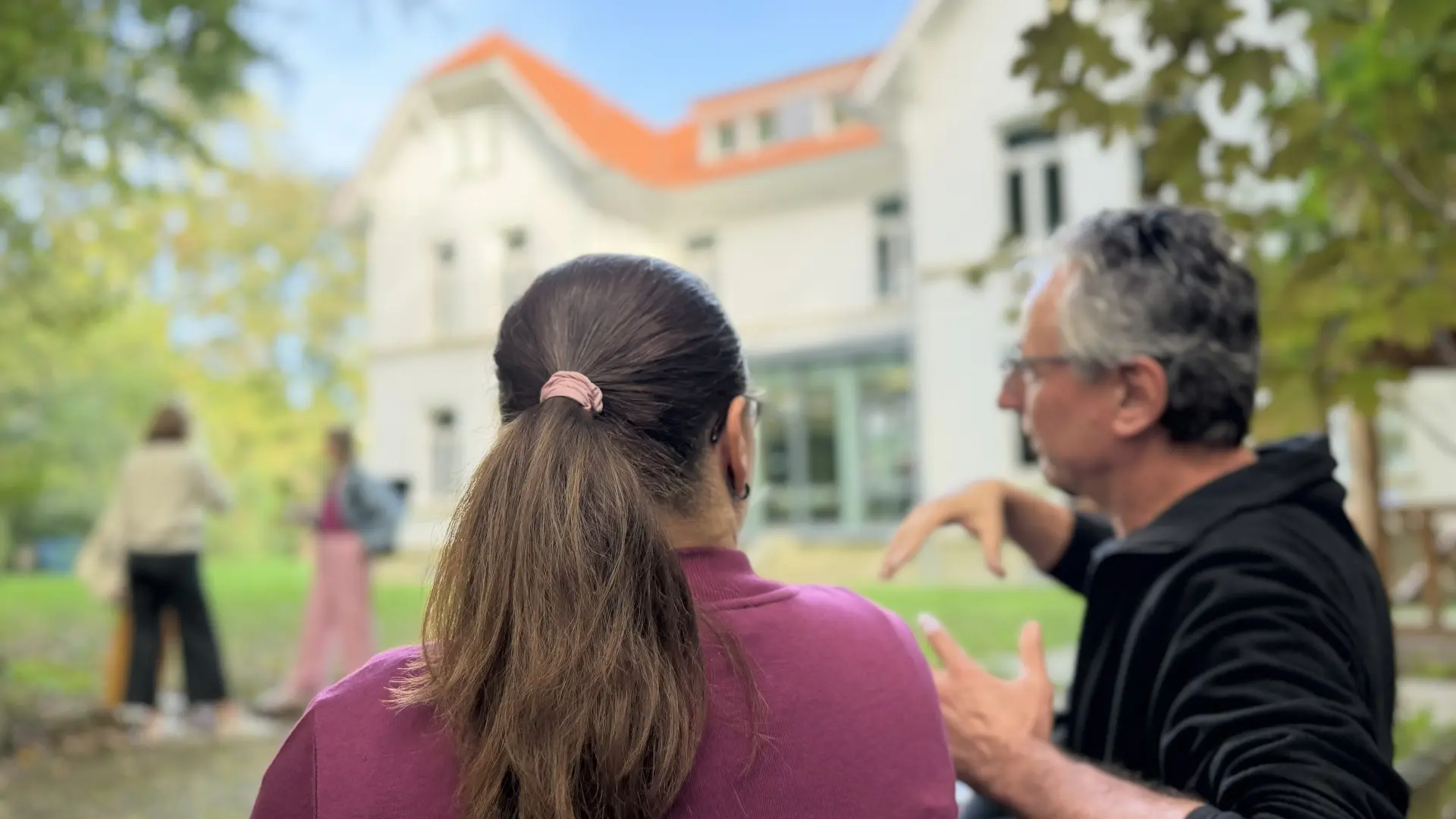 Menschen gehen in das Akademiegebäude.