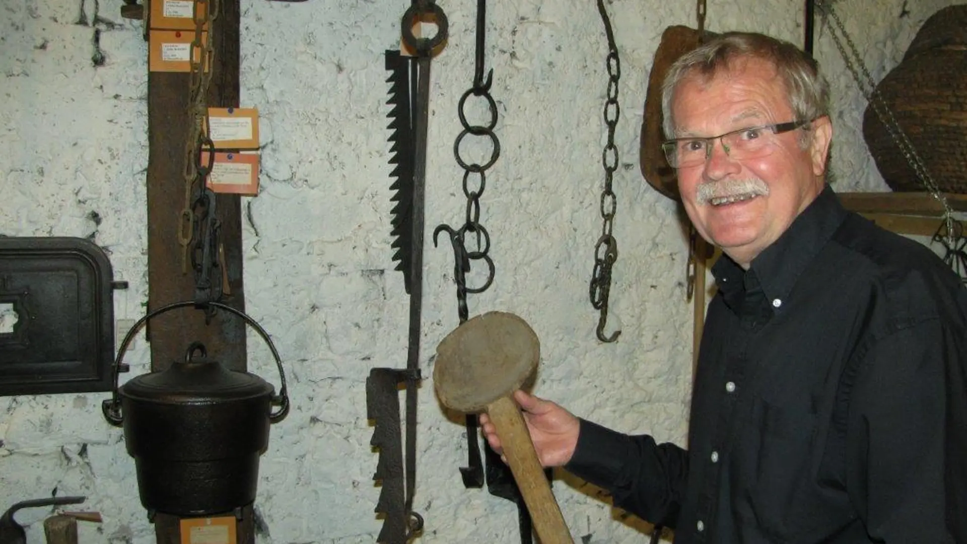 Gunter Altenkirch in seinem Museum für dörfliche Alltagskultur in Rubenheim mit einem Hammer in der Hand.