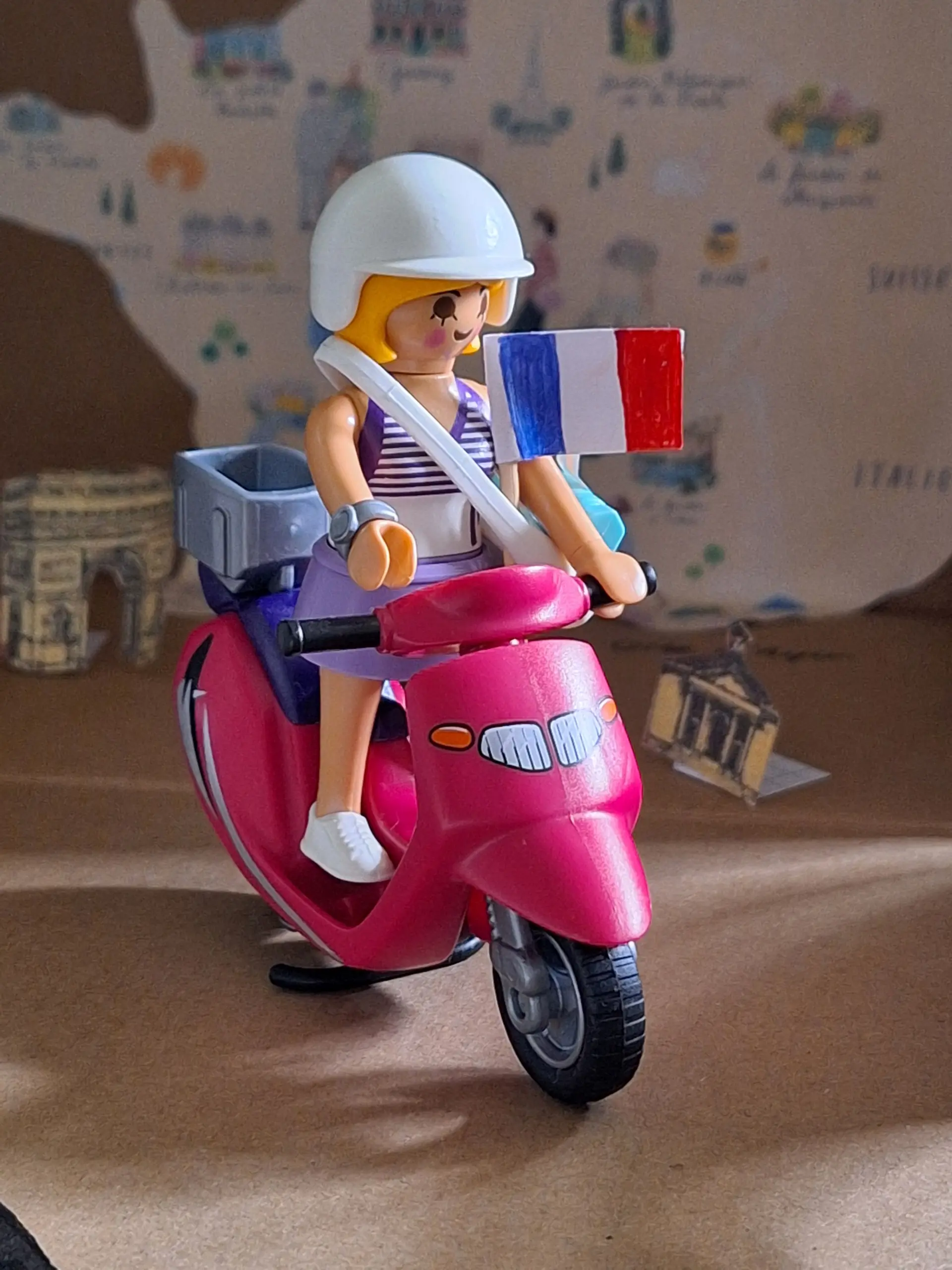 Das Bild zeigt eine Playmobilfigur weiblich, die auf einem Playmobilroller sitzt.