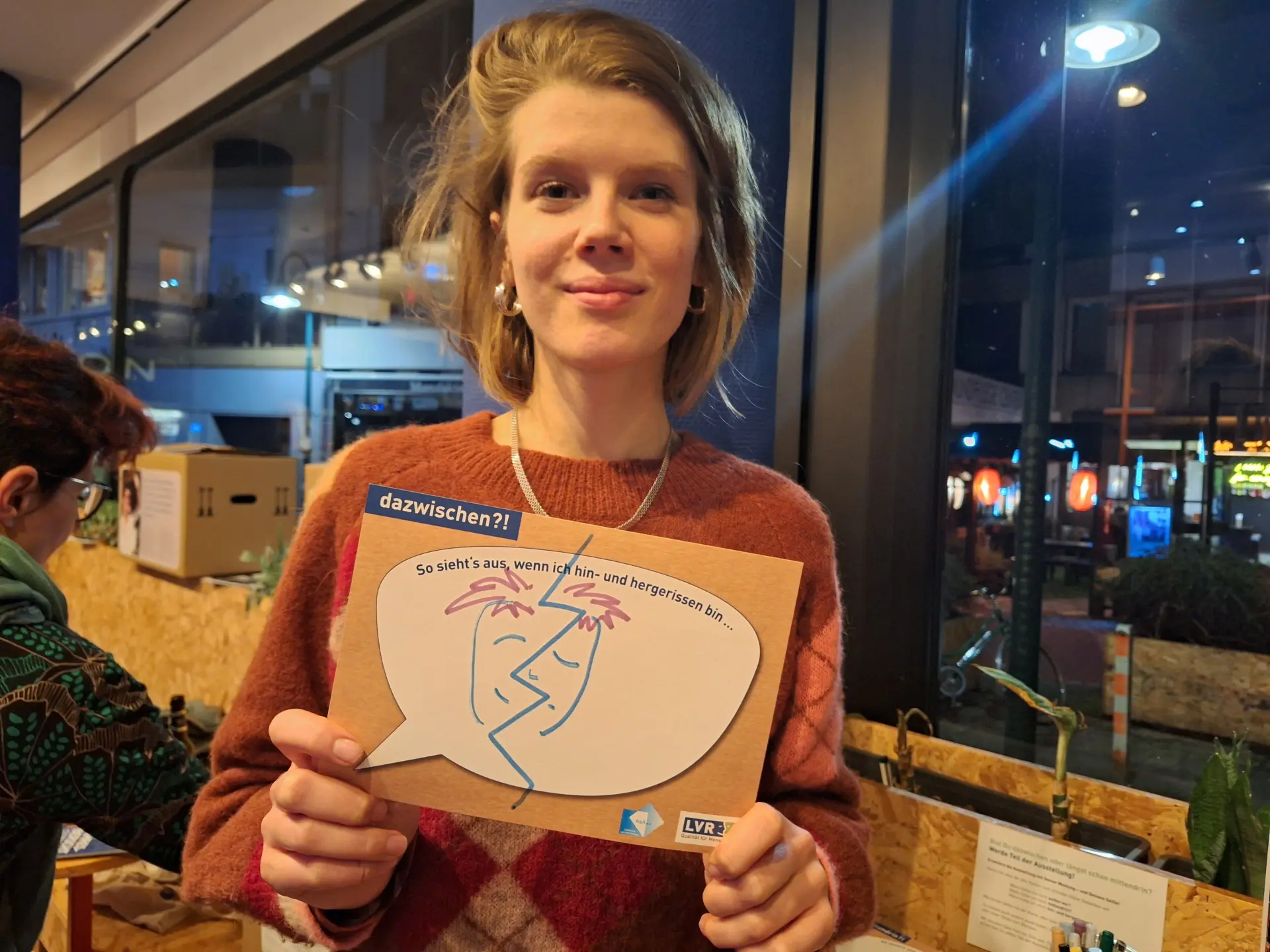 Fiona Sprack, Kooperationspartnerin vom Salon 53177 der Bundeskunsthalle, mit einer Mitmachkarte an der Selfie-Station der Ausstellung.