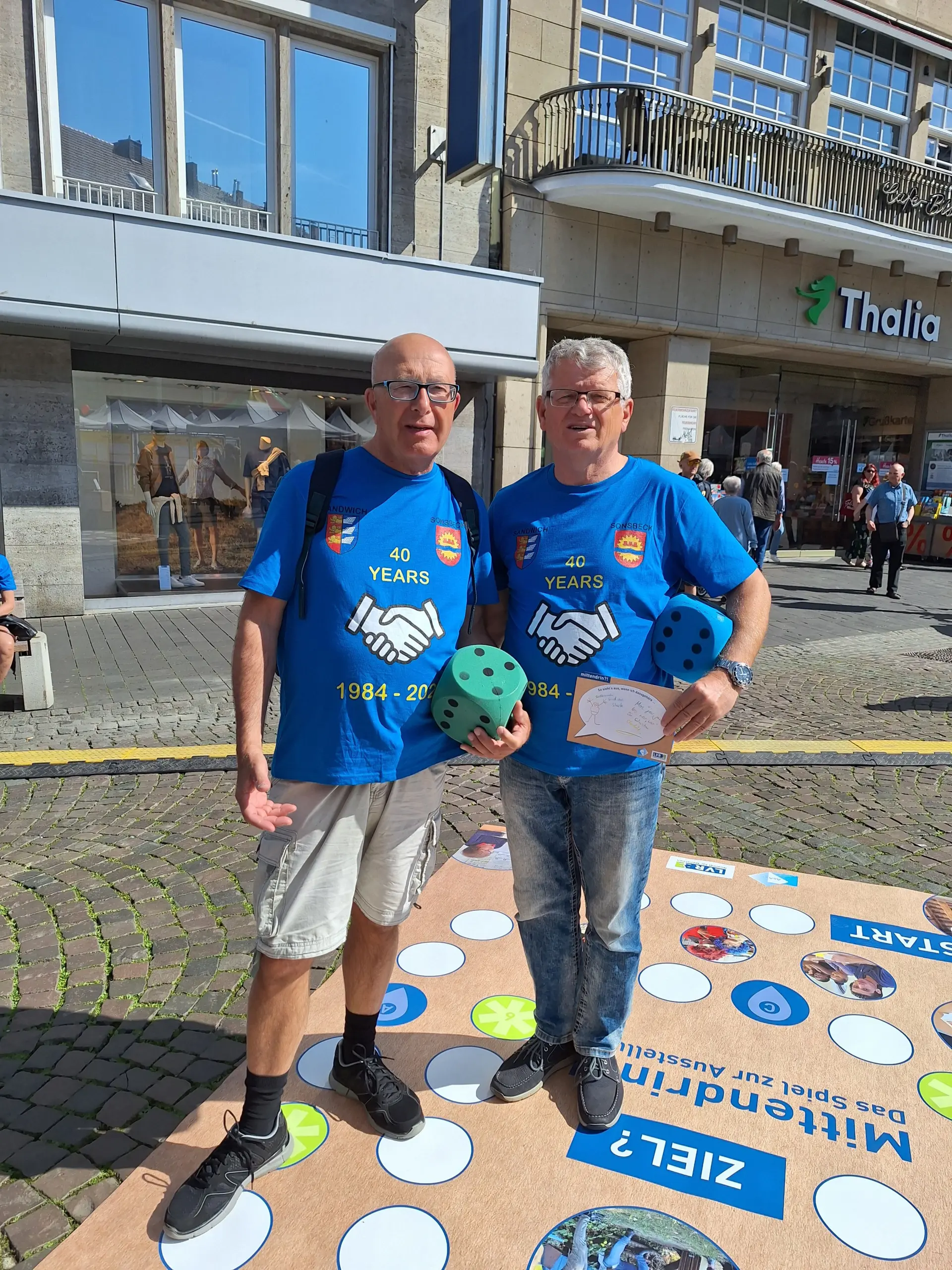 Passanten beim Bonner Europatag im Mai 2024 beteiligen sich am Spiel ‚Mittendrin‘ zur Ausstellung.