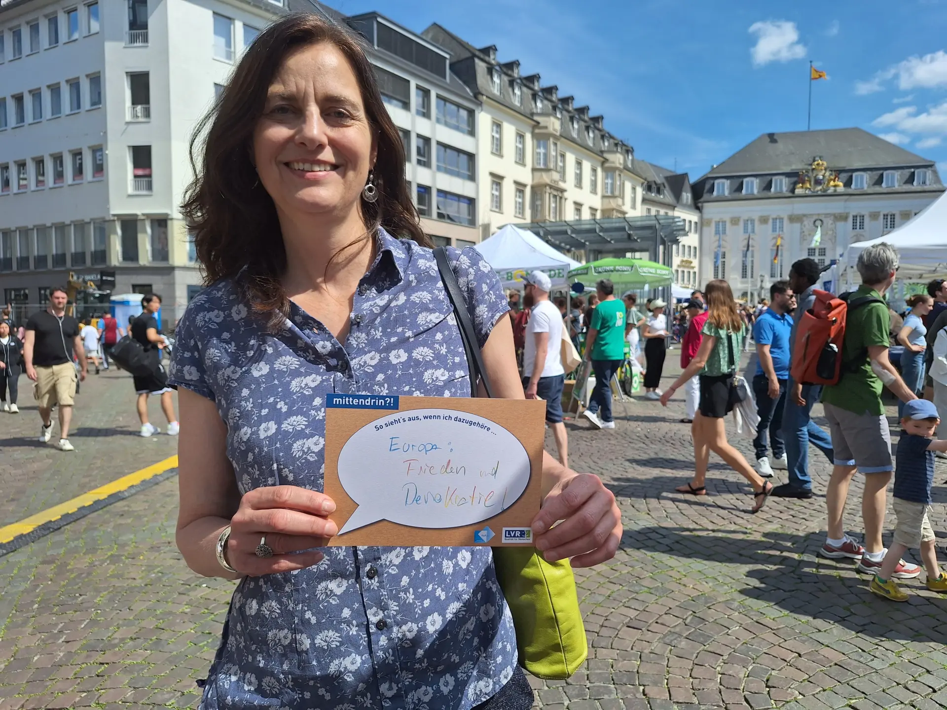Besucherin am Infostand der Ausstellung beim Bonner Europatag mit einer Mitmachkarte.
