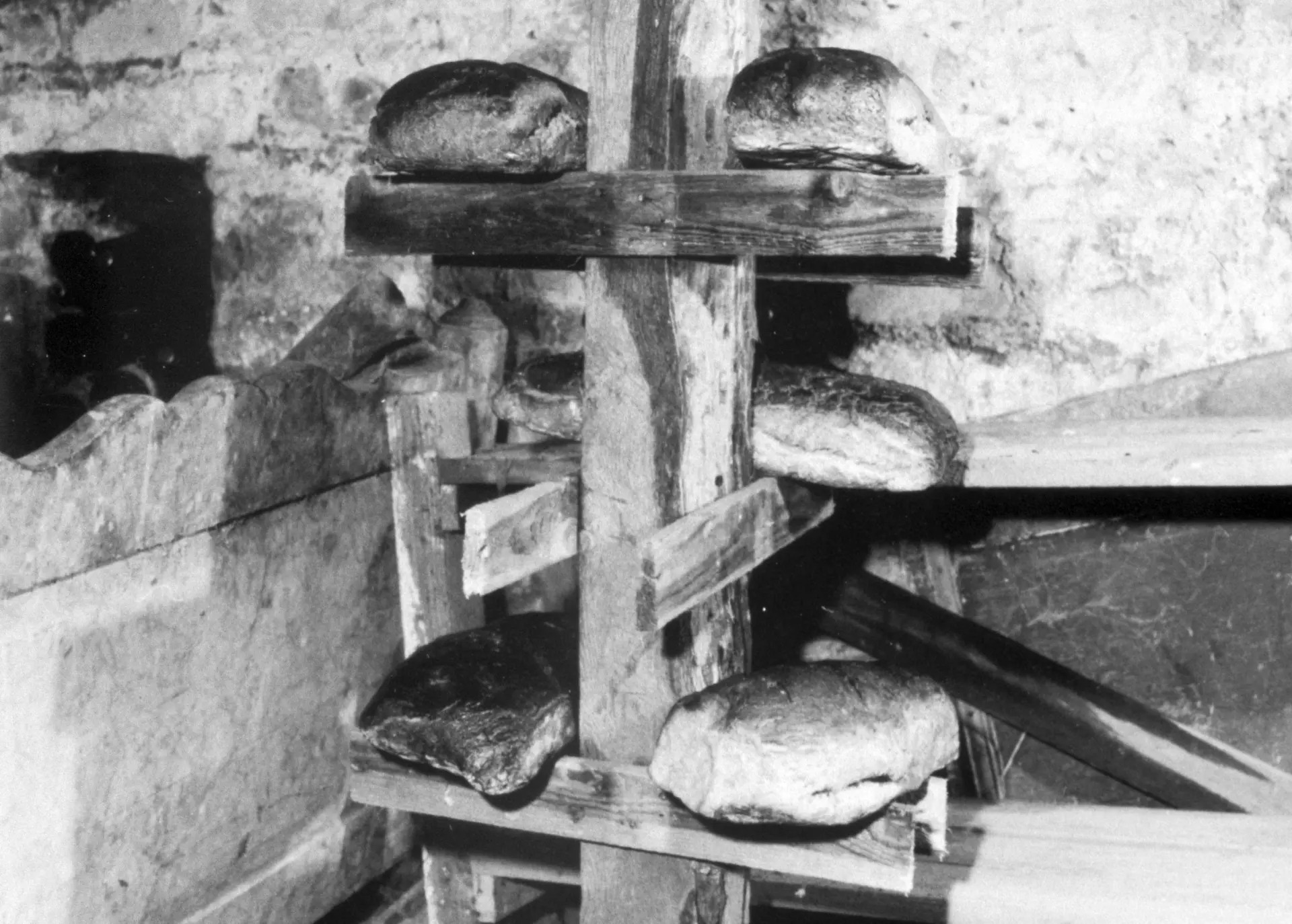 Im Gemeindebackhaus gebackene Brote aufbewahrt im Keller auf einem Brotgestell.