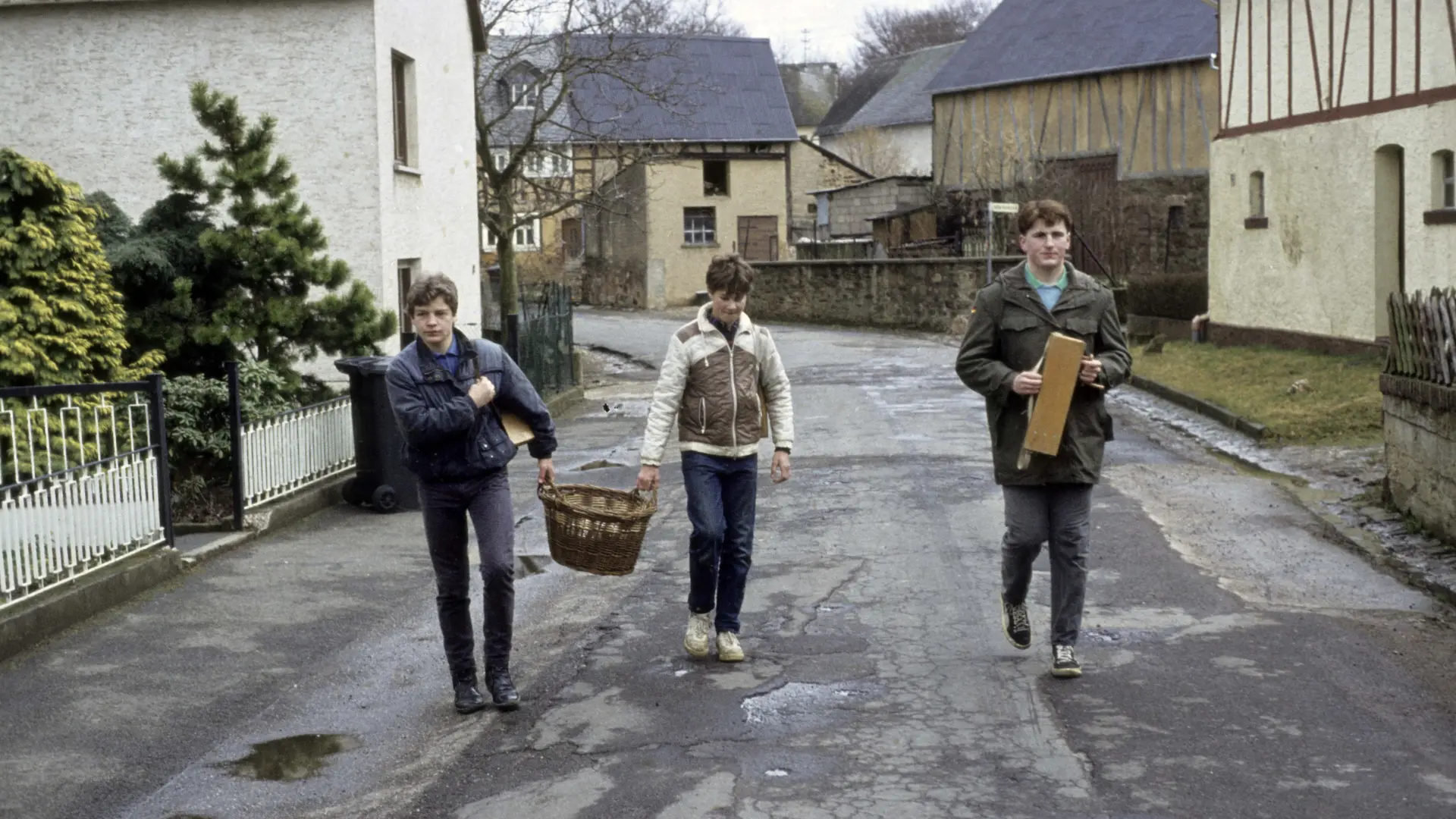 Aus der Filmdokumentation "Karklappern". Zu sehen sind drei junge männliche Personen nebeneinander gehend auf der Straße.