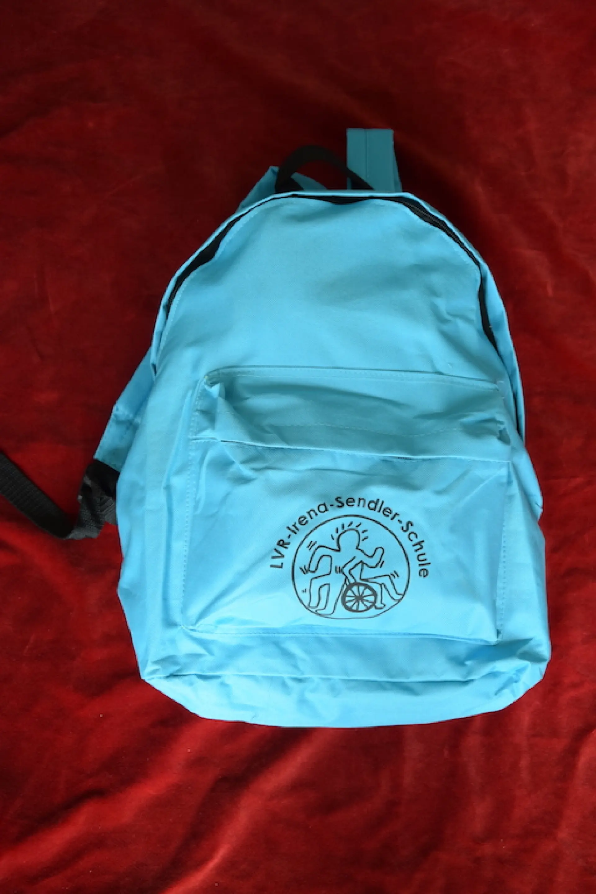 Produkt aus dem Shop des Fördervereins: hellblauer Rucksack mit Schullogo