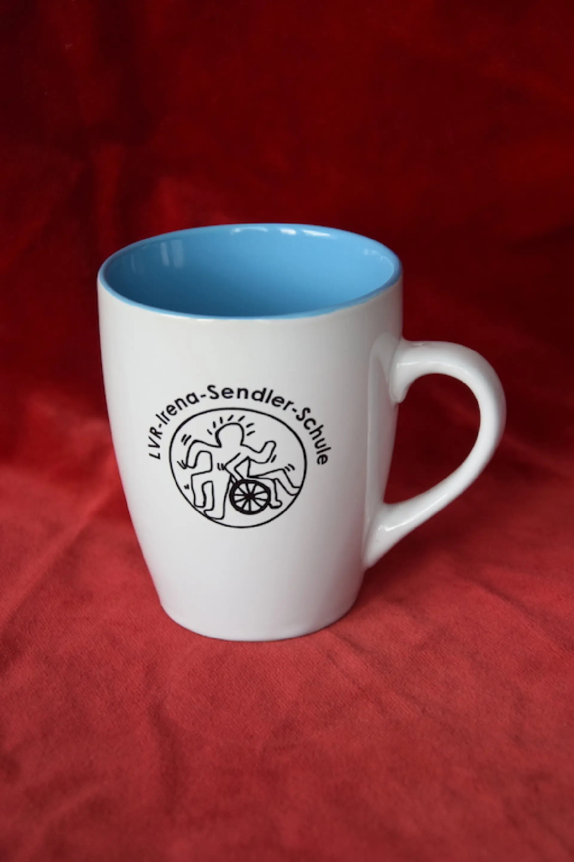 Produkt aus dem Shop des Fördervereins: weiße Tasse mit Logo