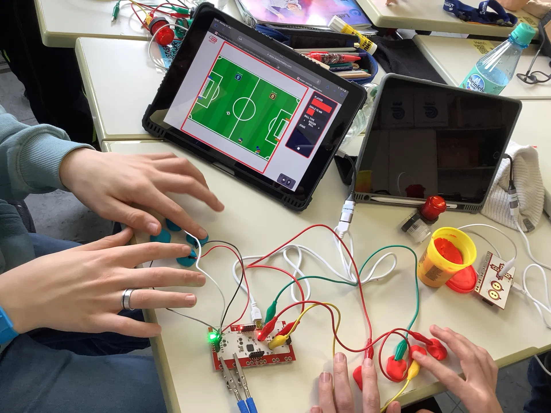 Schüler*innen montieren Platinen an ein iPad