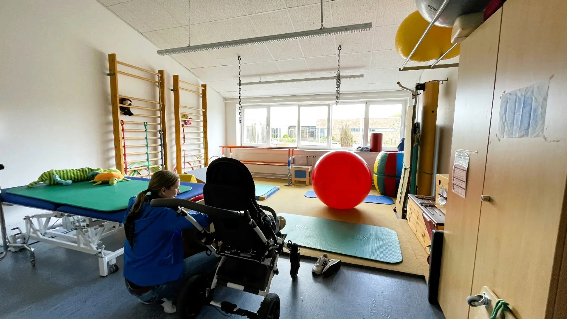 Schüler*in und Therapeutin im Physiotherapieraum der Schule