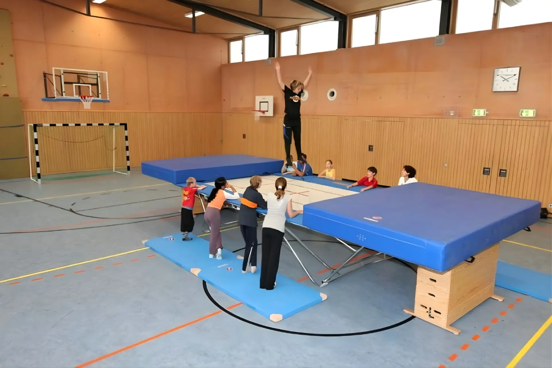 Kinder springen in Turnhalle auf einem Trampolin