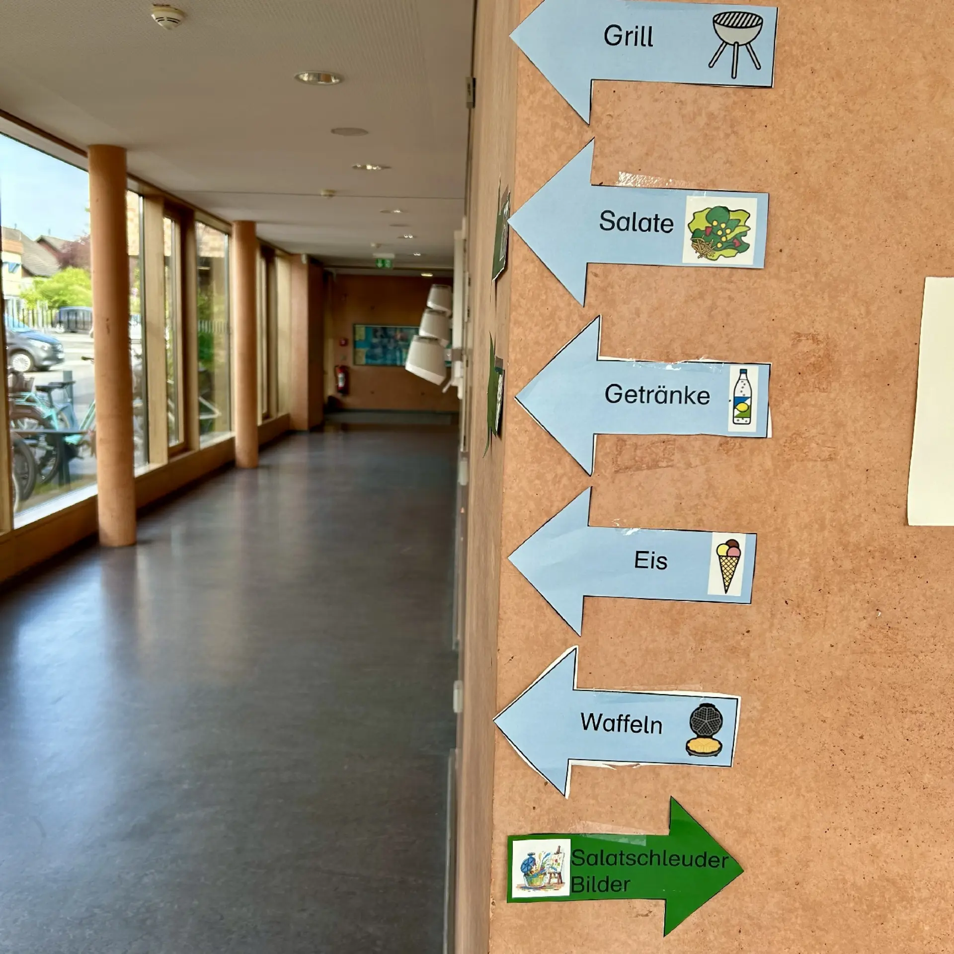 Selbstgebastelte Wegweiser aus Pappe auf dem Schulfest