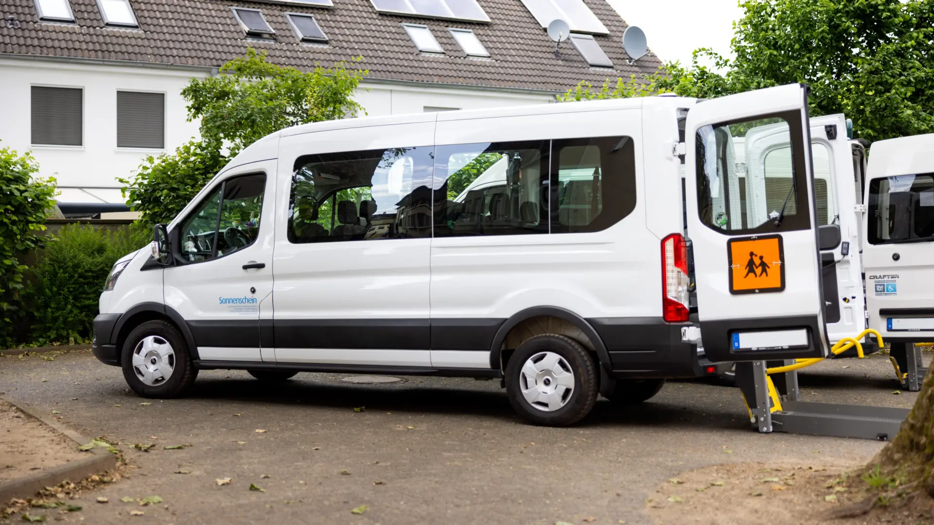 Rollstuhlfahrer fährt über eine Rampe in einen für Rollstühle ausgebauten Wagen rein.