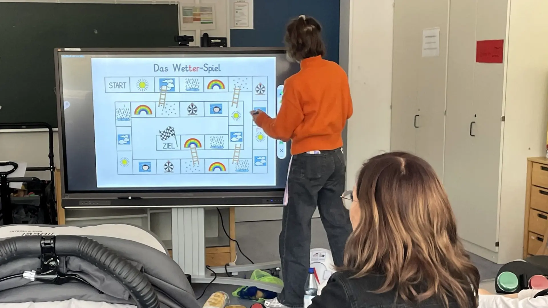 Angebot für Unterstützte Kommunikation: Lehrerin zeigt Wetterspiel an digitaler Tafel