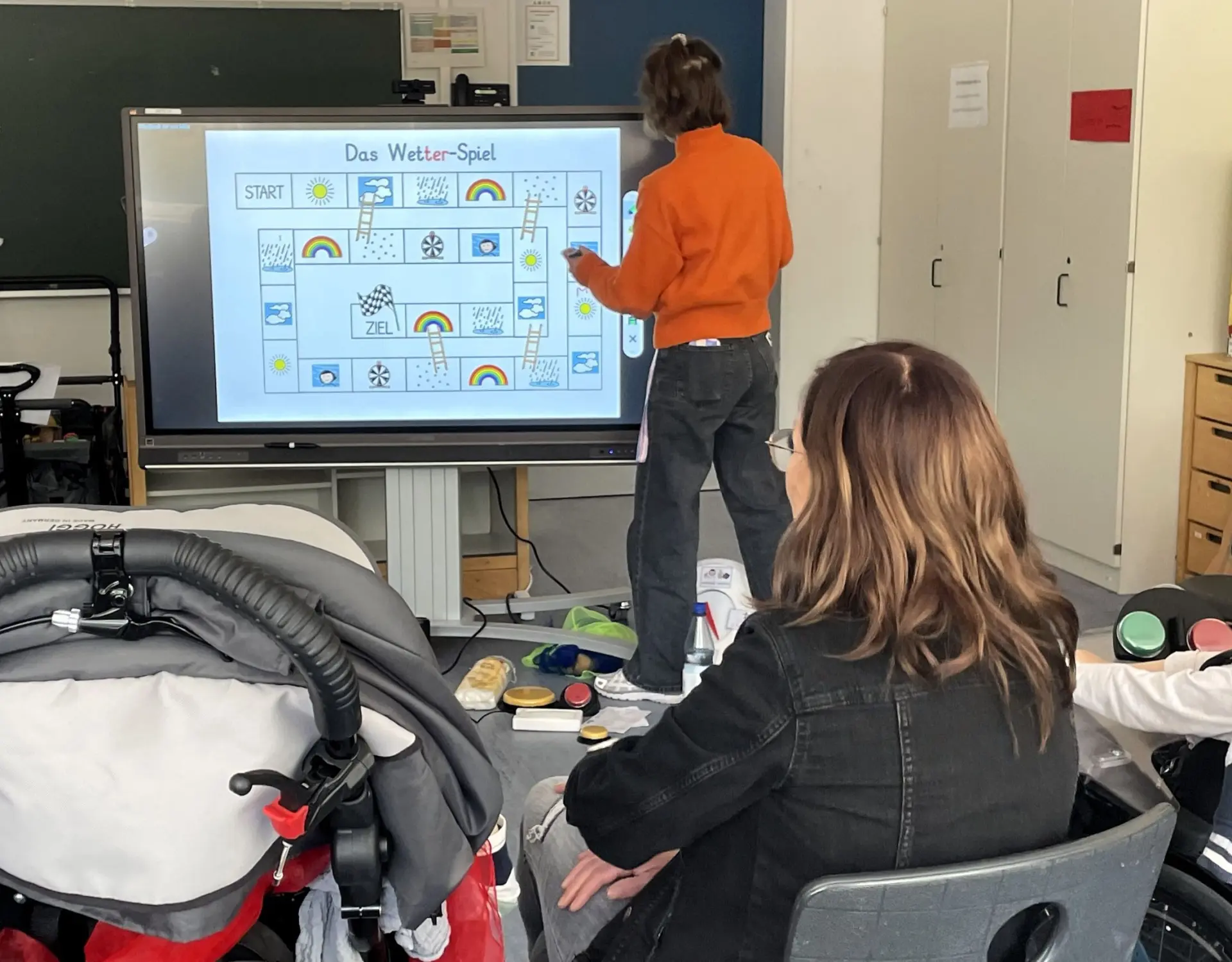 Angebot für Unterstützte Kommunikation: Lehrerin zeigt Wetterspiel an digitaler Tafel