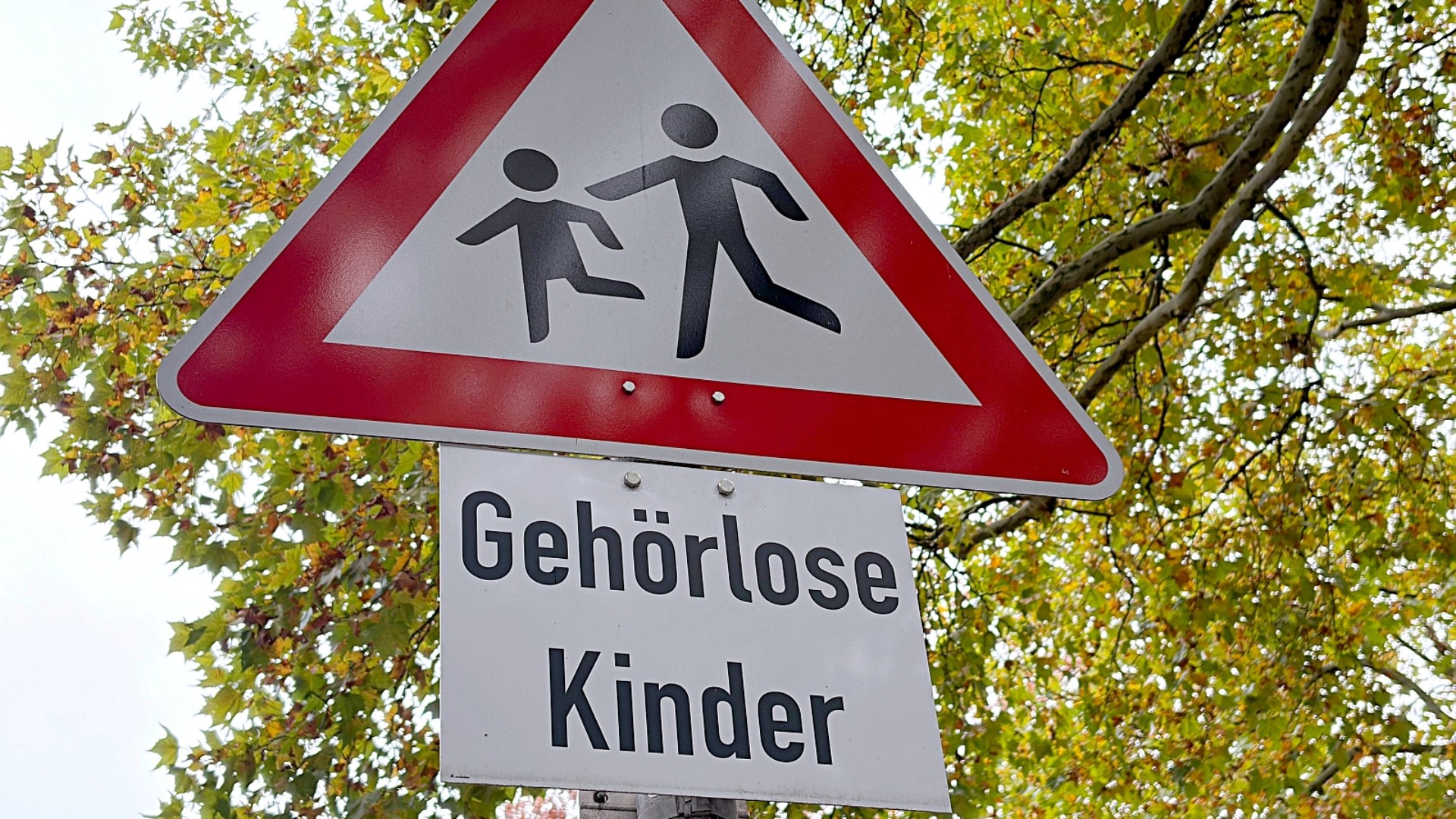 Verkehrsschild: Achtung Kinder mit dem Zusatzschild: Gehörlose Kinder