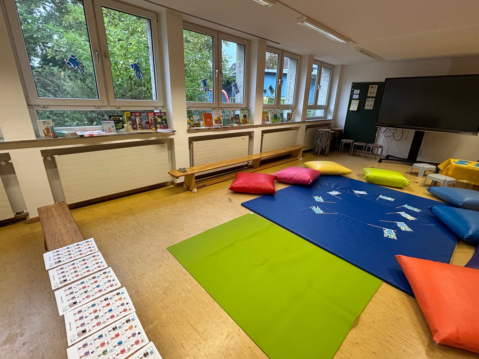 Ein Raum mit Sitzkreis in der Mitte und vielen Büchern auf der Fensterbank.