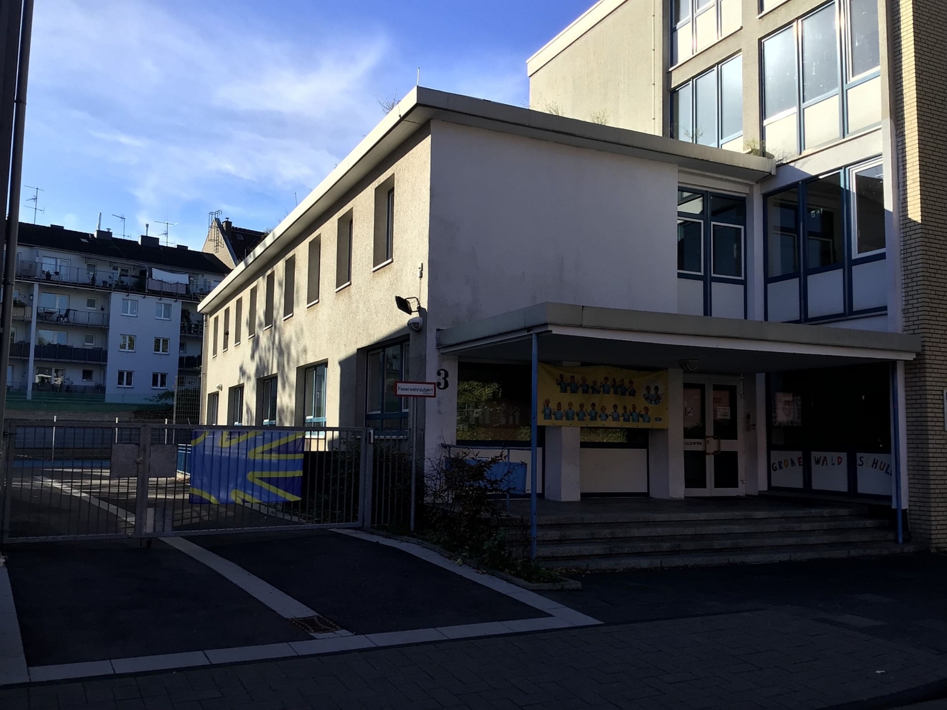 Blick auf das Gebäude der Primarstufe: Am Tor zum Schulhof hängt die Gehörlosen-Flagge.