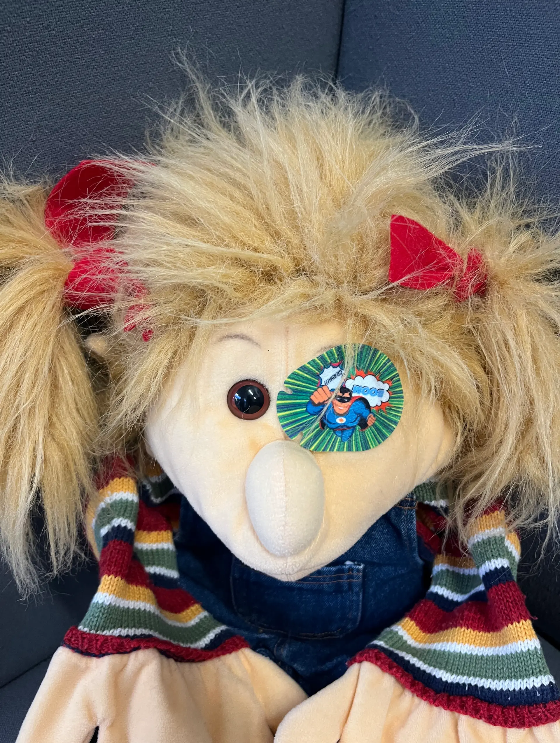 Handpuppe mit einem Okklusionspflaster auf dem linken Auge.