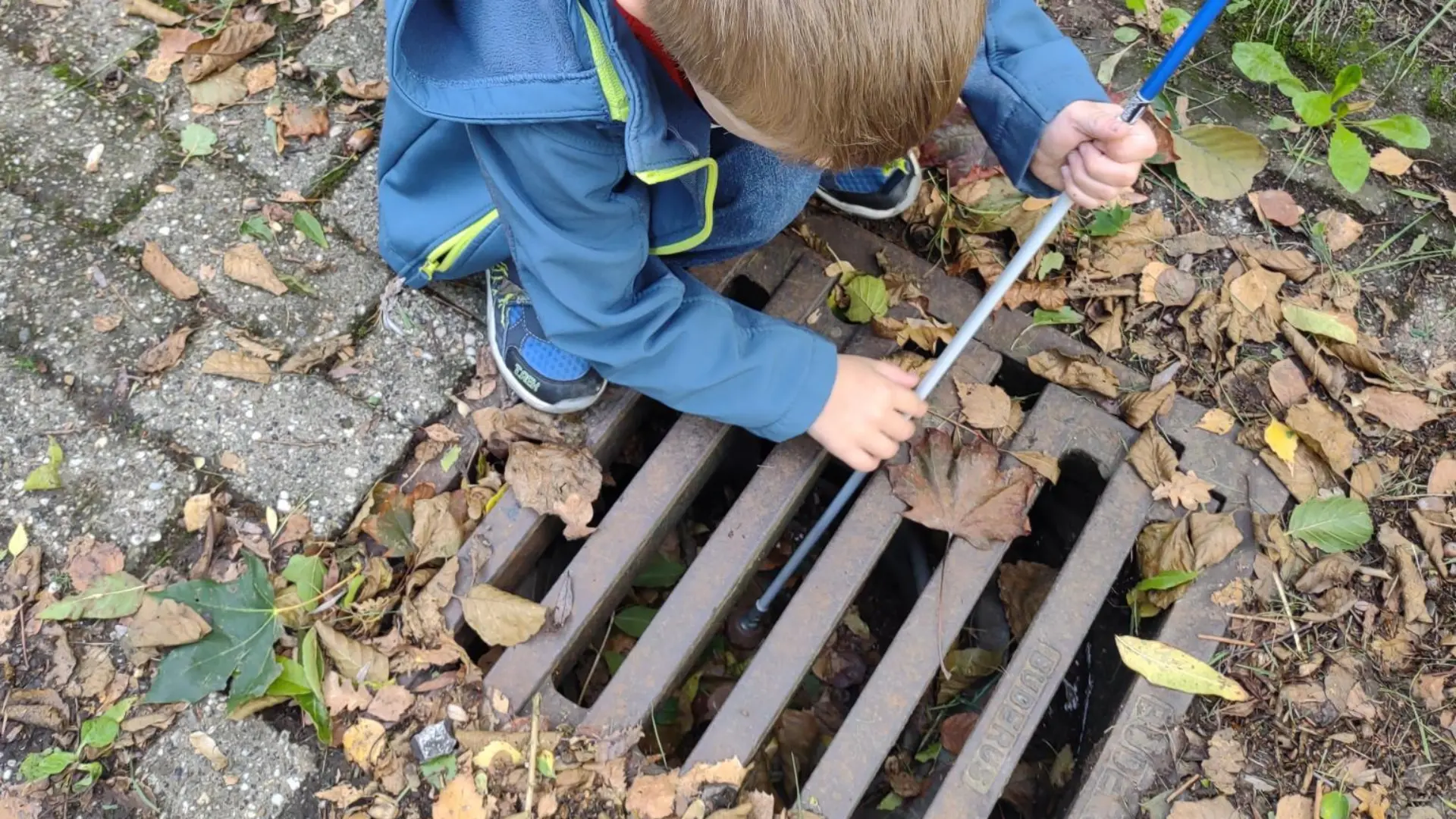 Kinder erkunden Leitsystem auf dem Boden mit Blindenstock