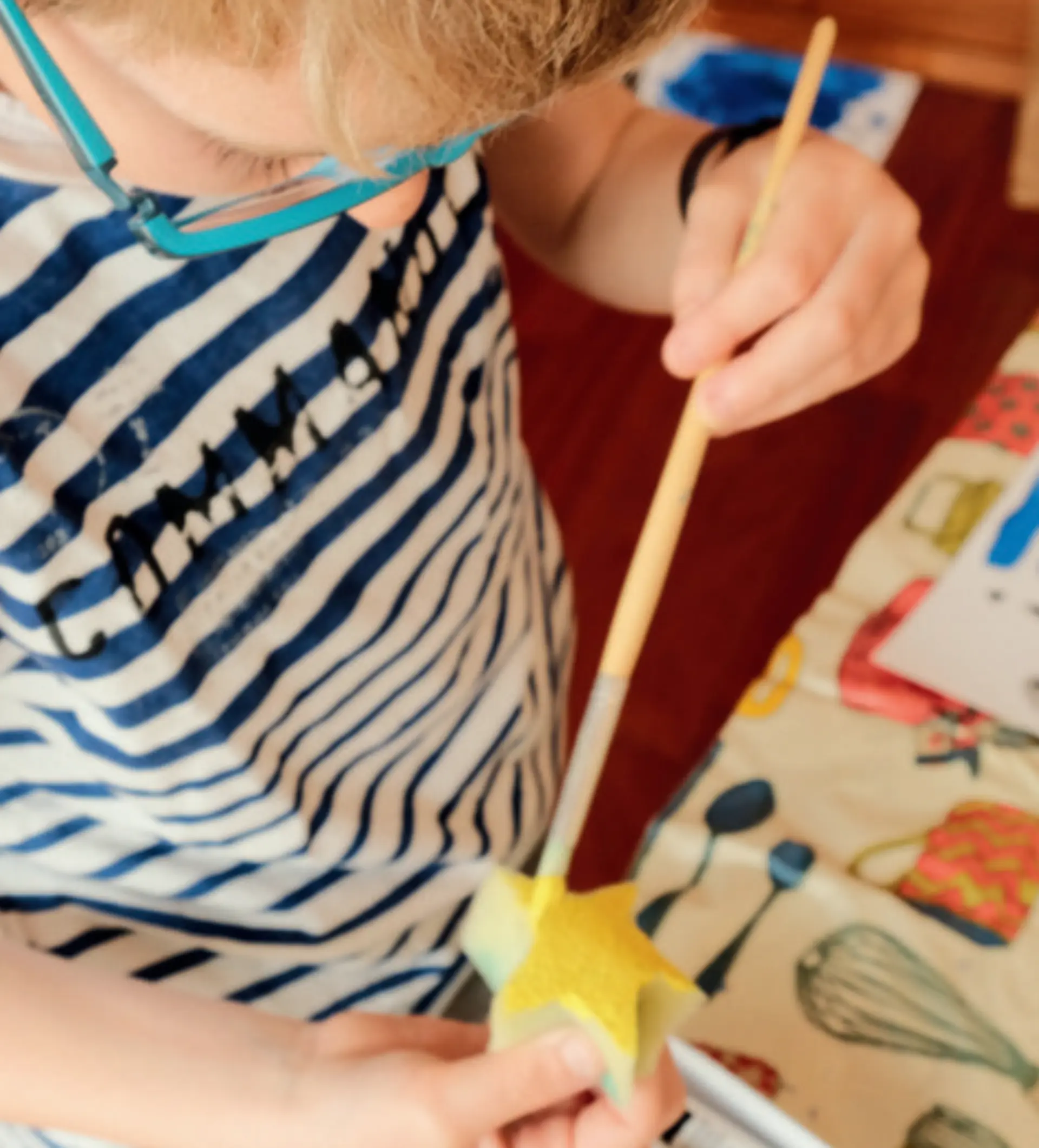 Kind bemalt einen Stern im Unterricht