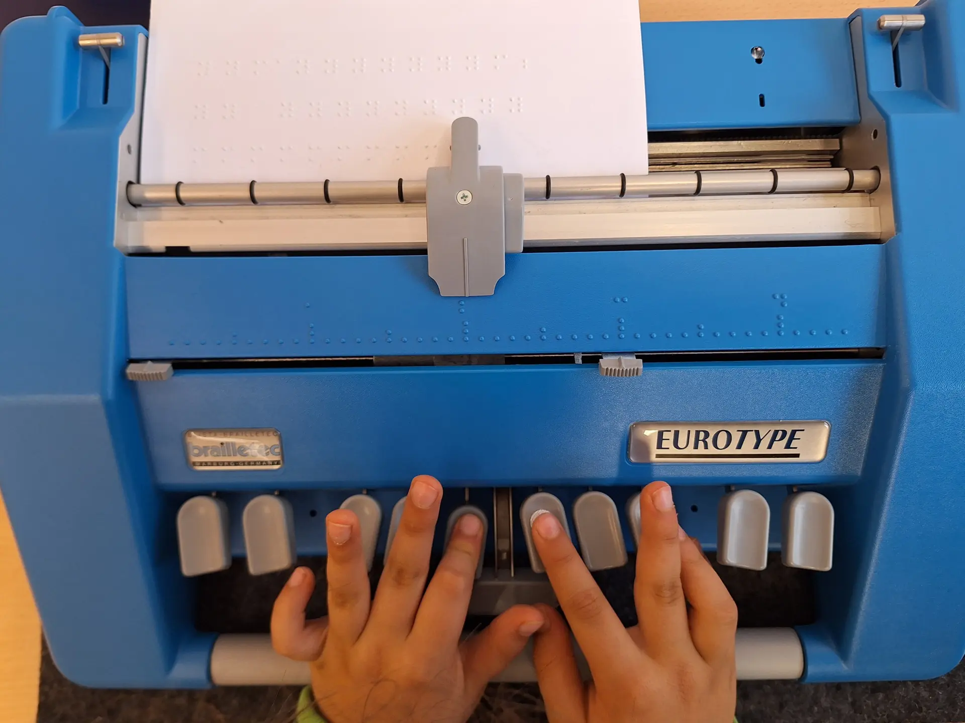 Kind schreibt in Primarstufe mit Punktschrift