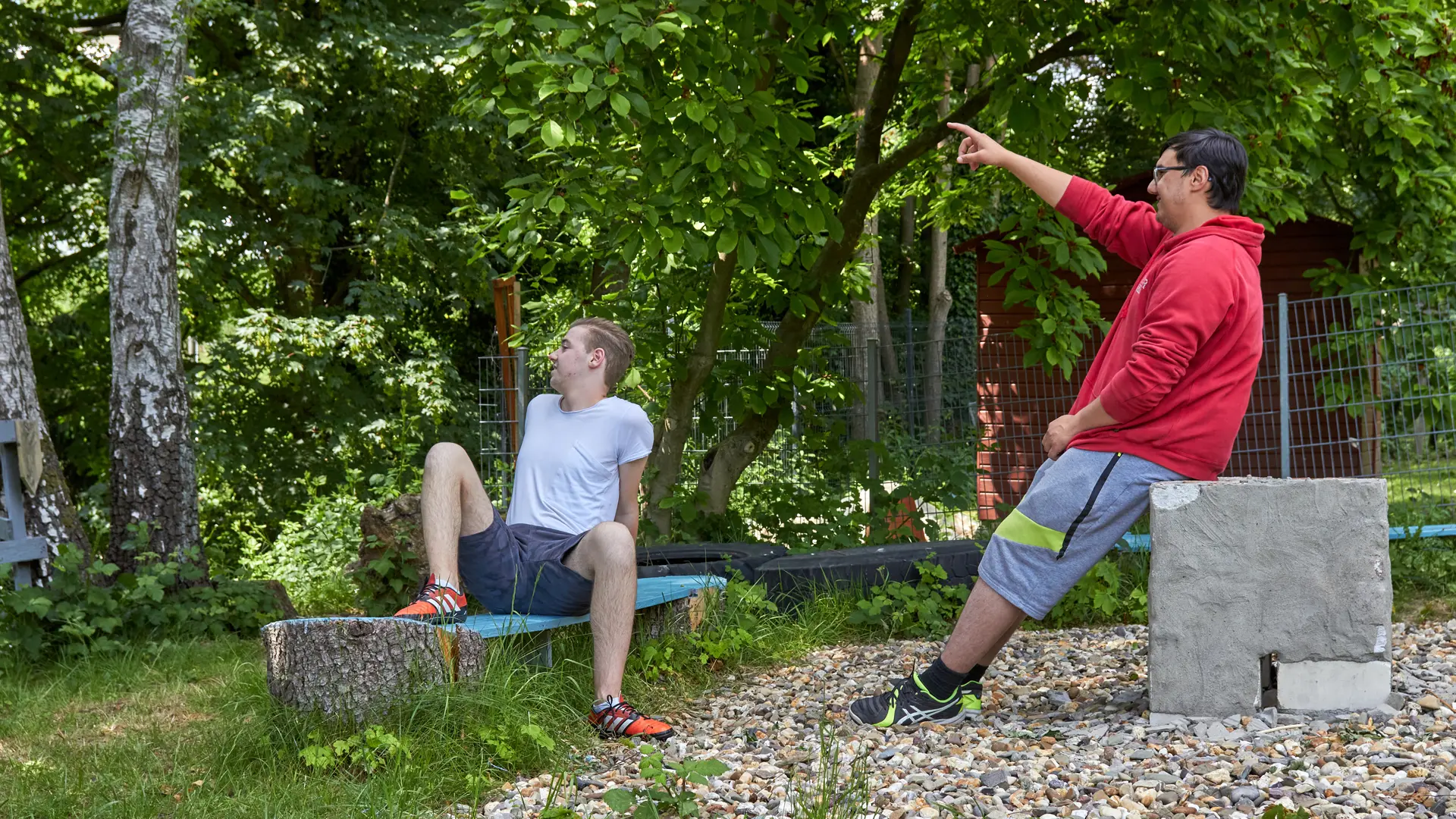 zwei männliche Teenager sitzen im Garten zusammen