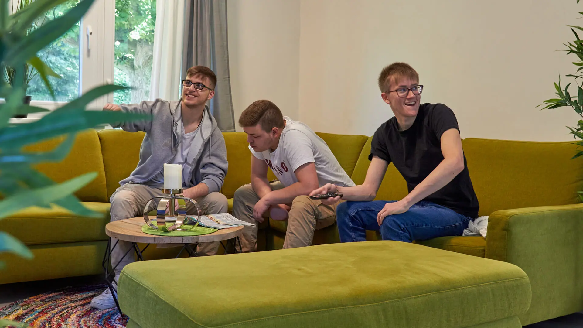 drei männliche Teenager sitzen zusammen auf der Couch