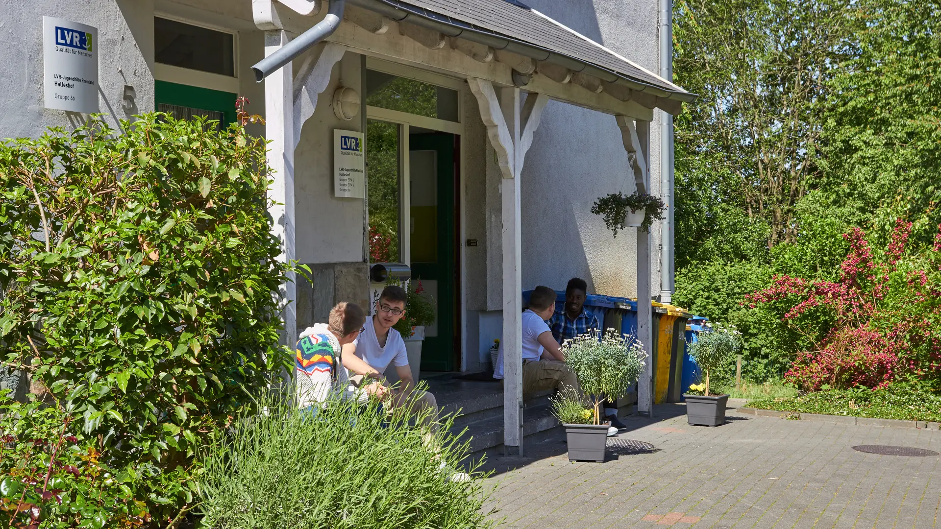 männliche Teenager sitzen auf der Veranda des Wohngruppenhauses