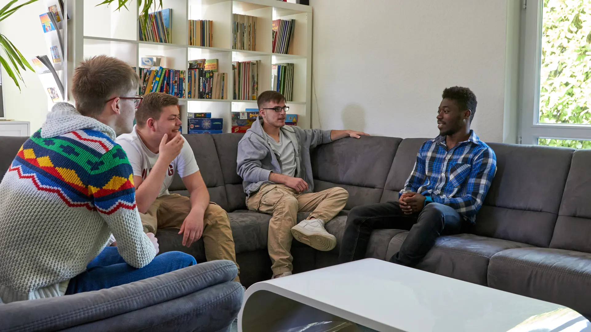 männliche Teenager sitzen im Wohnzimmer zusammen