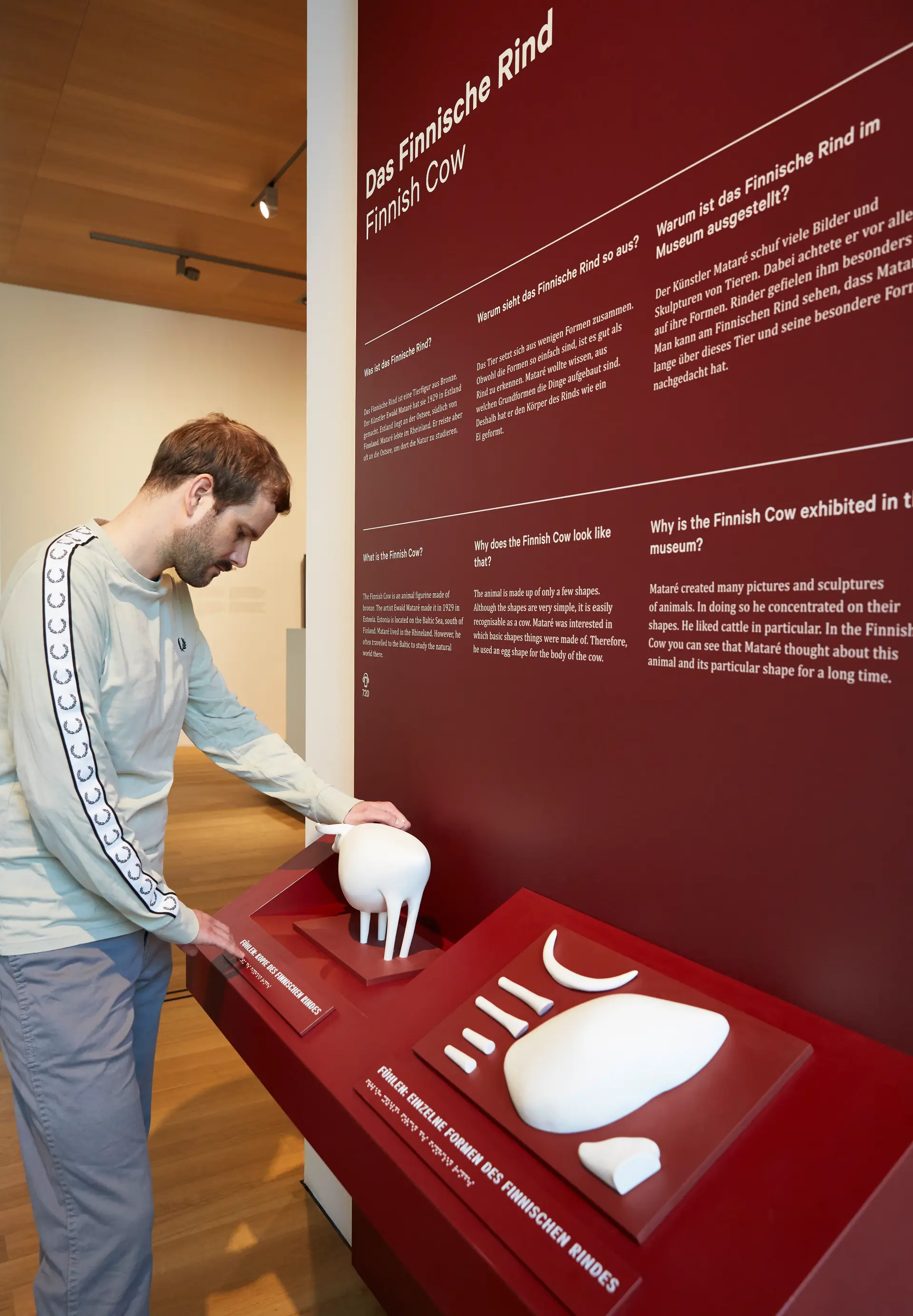 Ein Mann berührt an einer Tast-Station in der Dauerausstellung des Landesmuseums eine Skulptur.