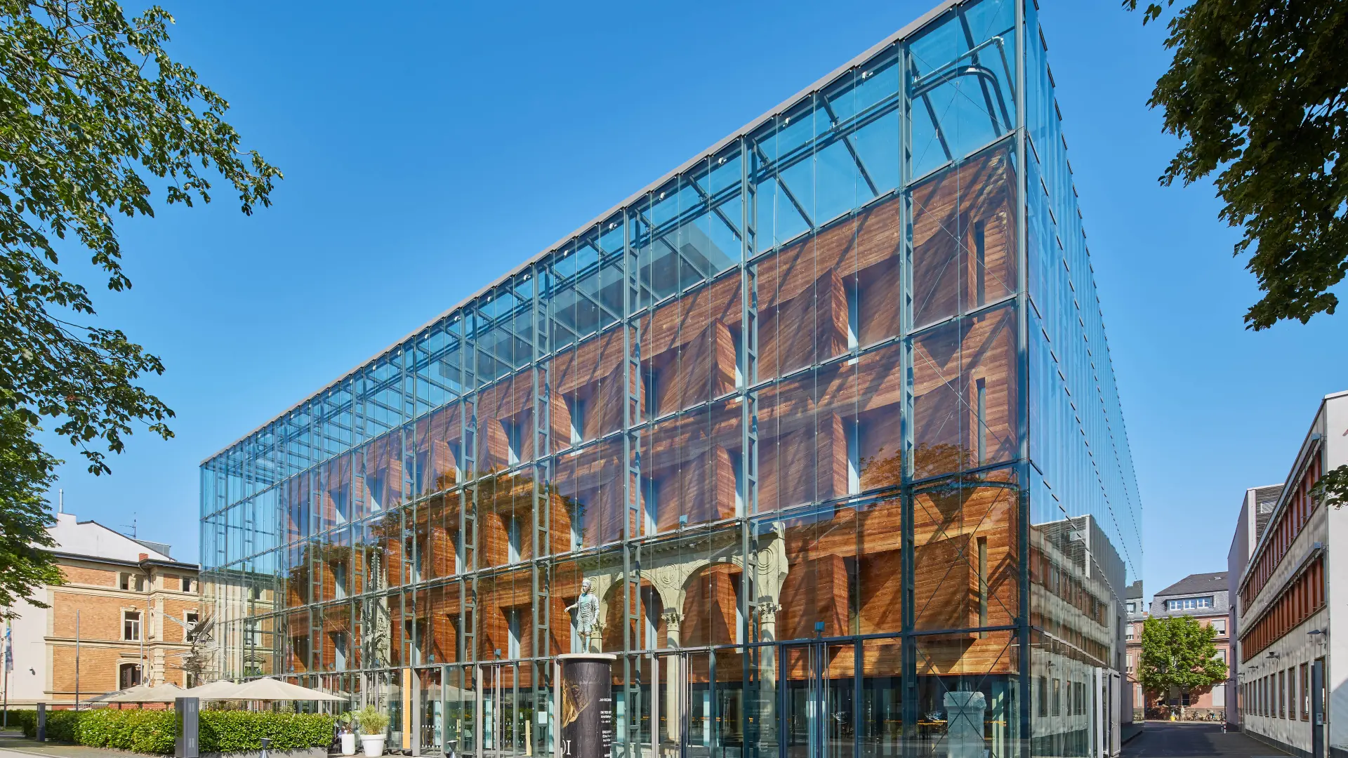 Die gläserne Fassade des Landesmuseums bei blauem Himmel.