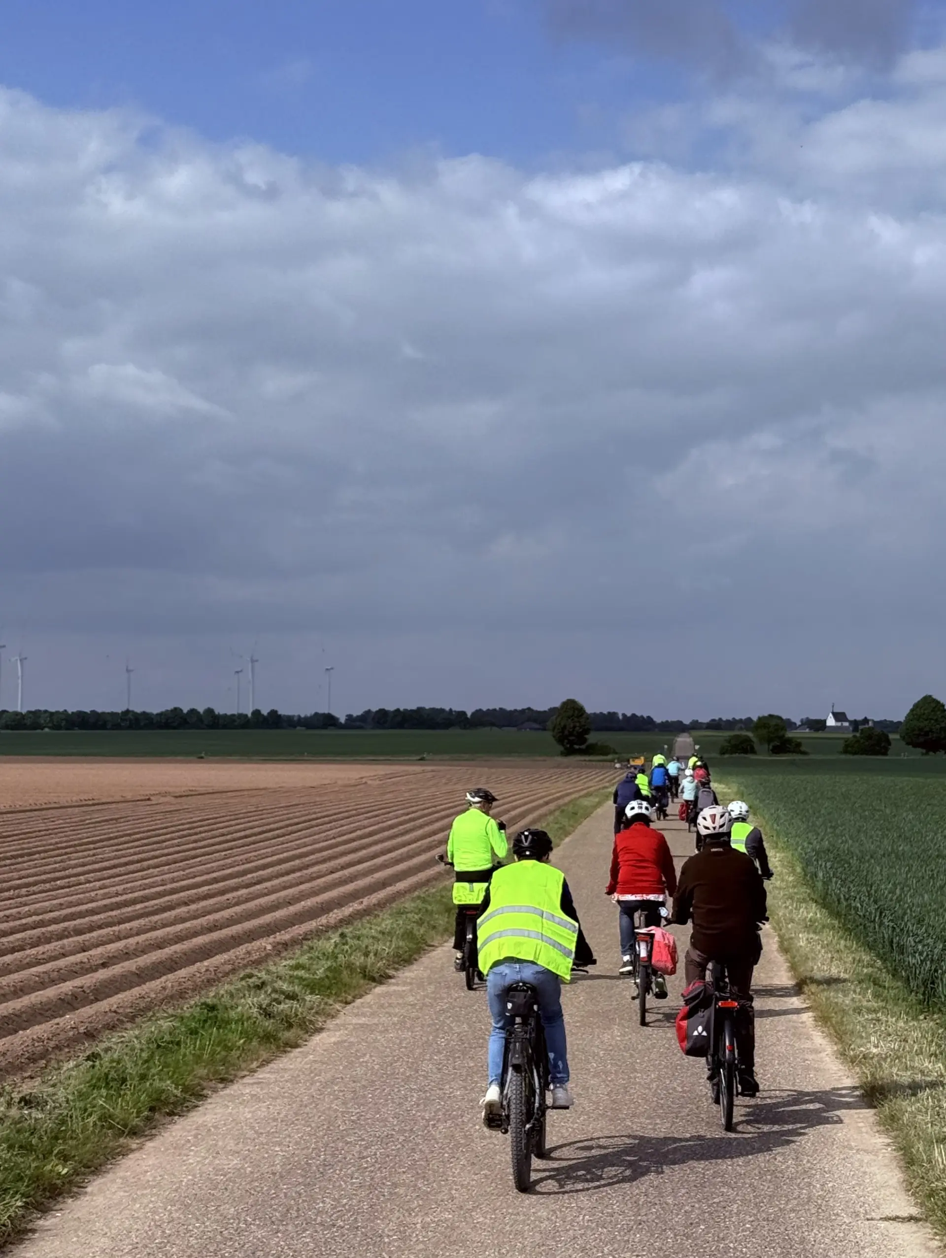 Eine Gruppe von Fahrradfahrern fährt über einen Weg entlang von 