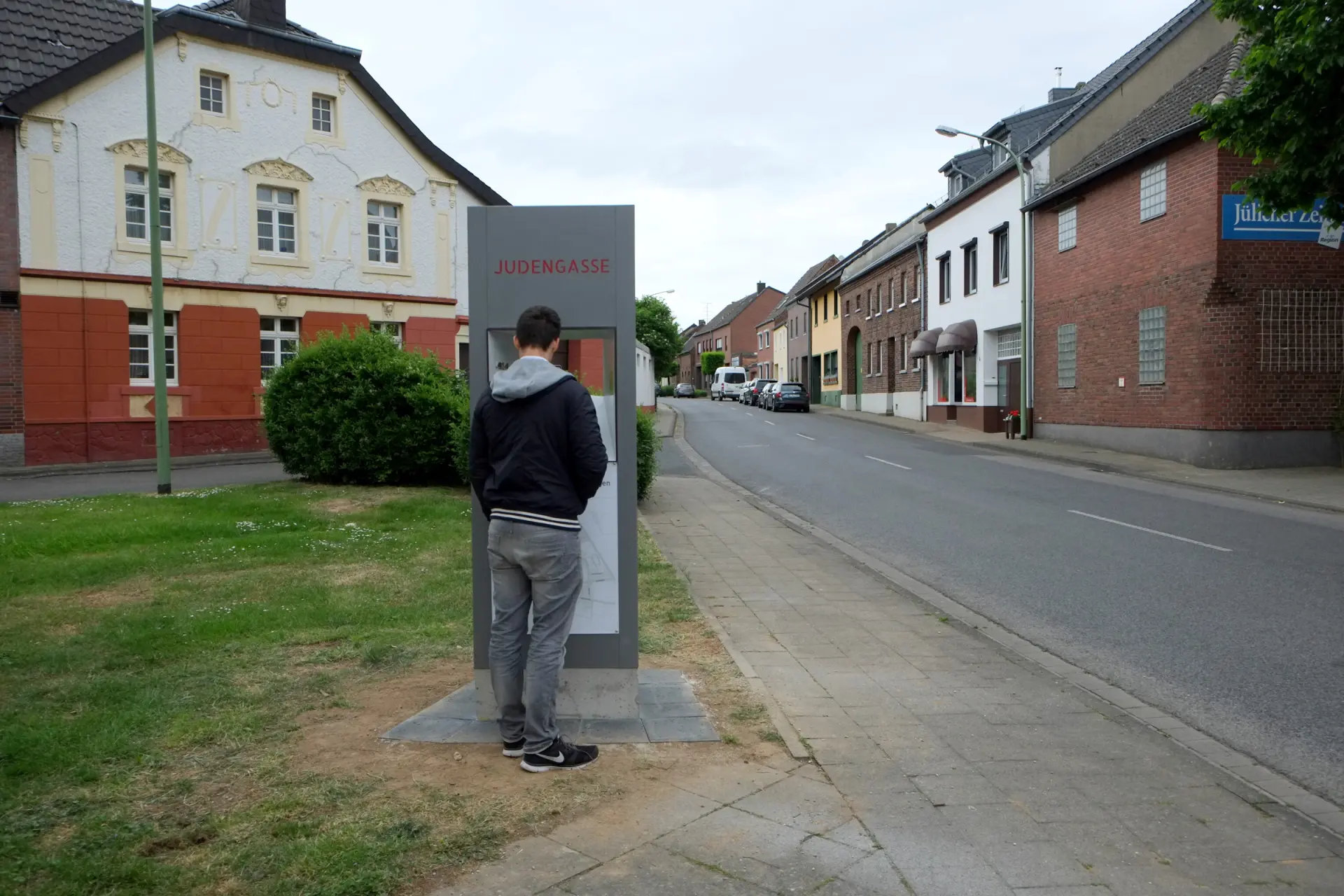 Ein Mann liest die Informationen im Durchguck der Info-Stele "Judengasse".