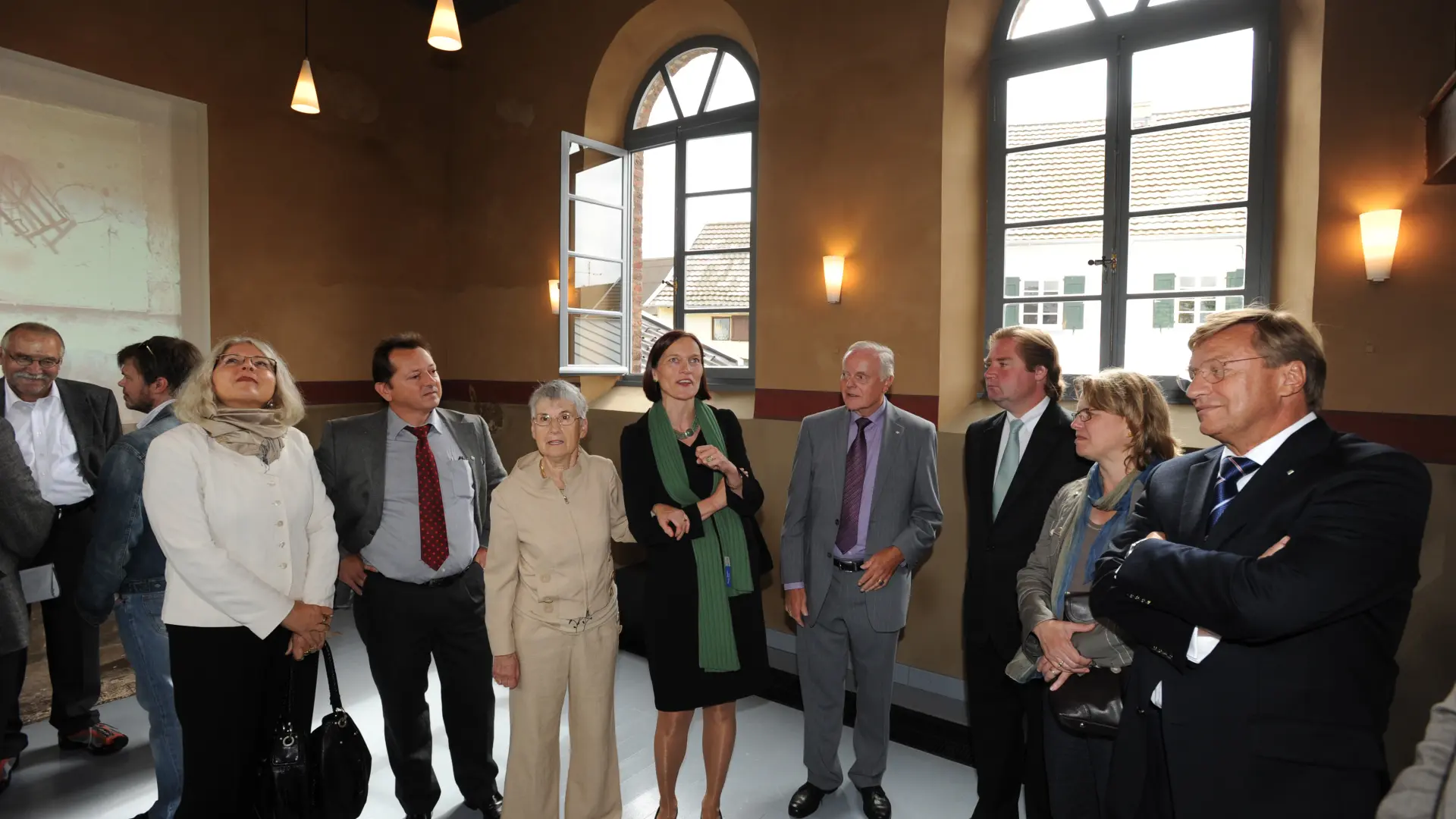 Mehrere Menschen stehen in der Landsynagoge und schauen sich in dem Raum um.