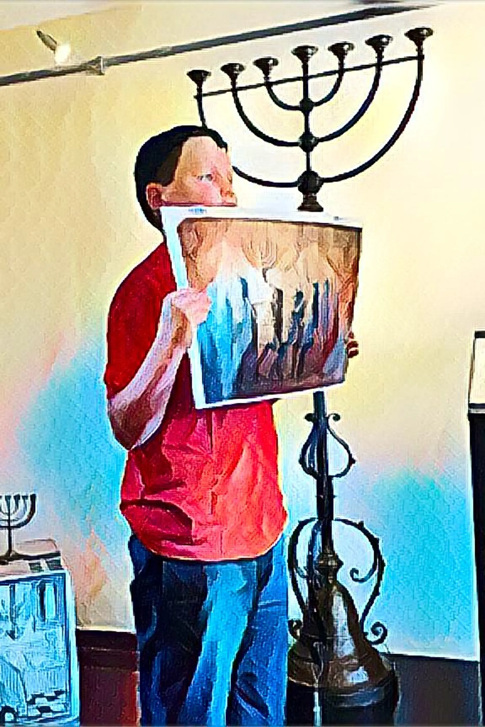 Ein Schüler hält ein Bild vor sich in die Höhe. Hinter ihm steht ein Leuchter.