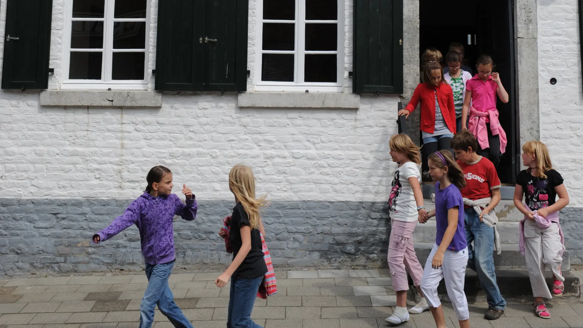 Ein Gruppe von Schülerinnen und Schülern verlässt das LVR-Kulturhaus und rennt in eine Richtung.