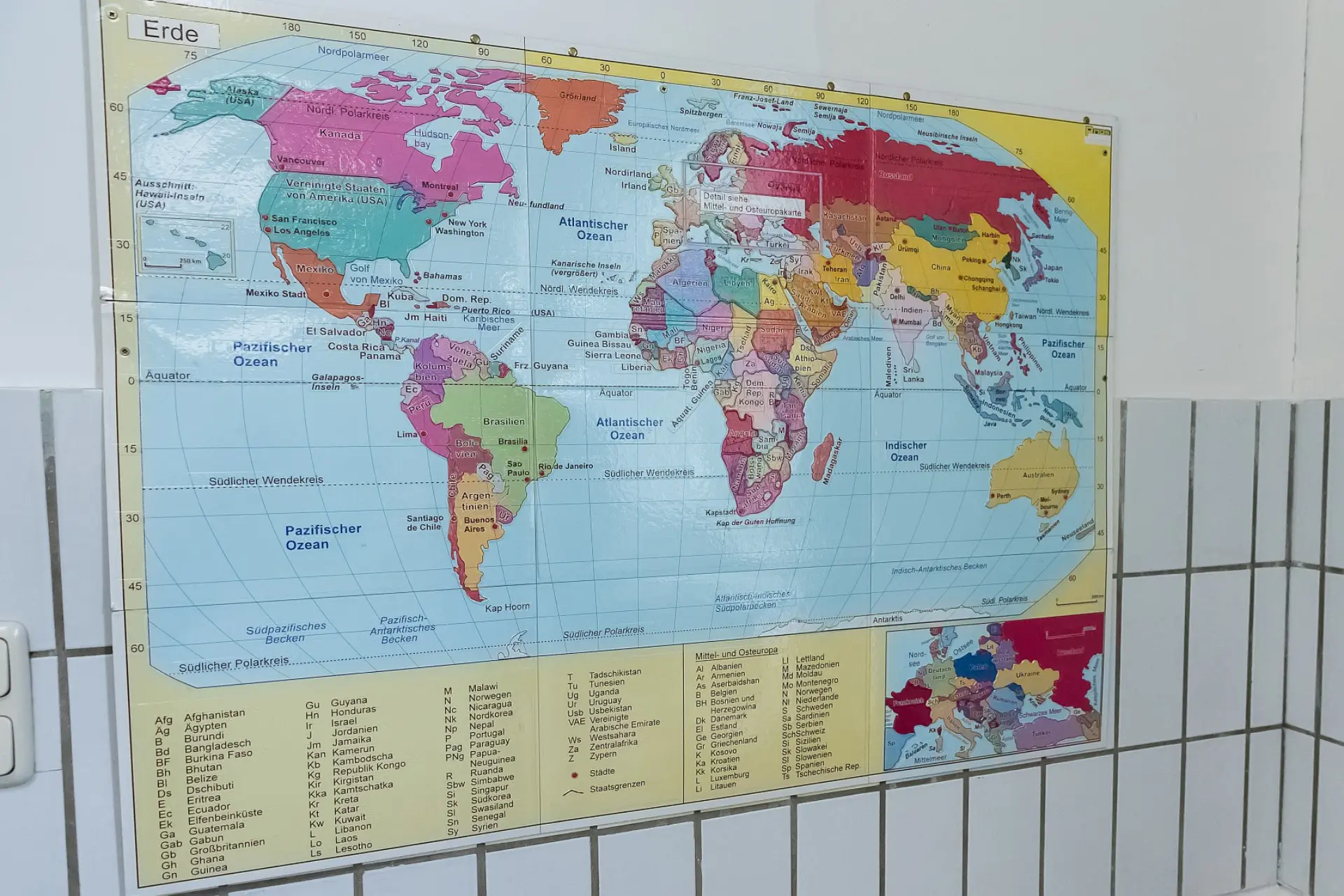 Plakat an der Wand, auf dem alle Länder und Ozeane zu sehen sind. Unter dem Bild sind die Namen von mehreren Ländern aufgelistet, für die der Platz auf dem Bild nicht gereicht hat. Dazu gibt es noch ein Bild nur mit den Ländern Europas, wo die Grenzen dazwischen abgetastet werden können.