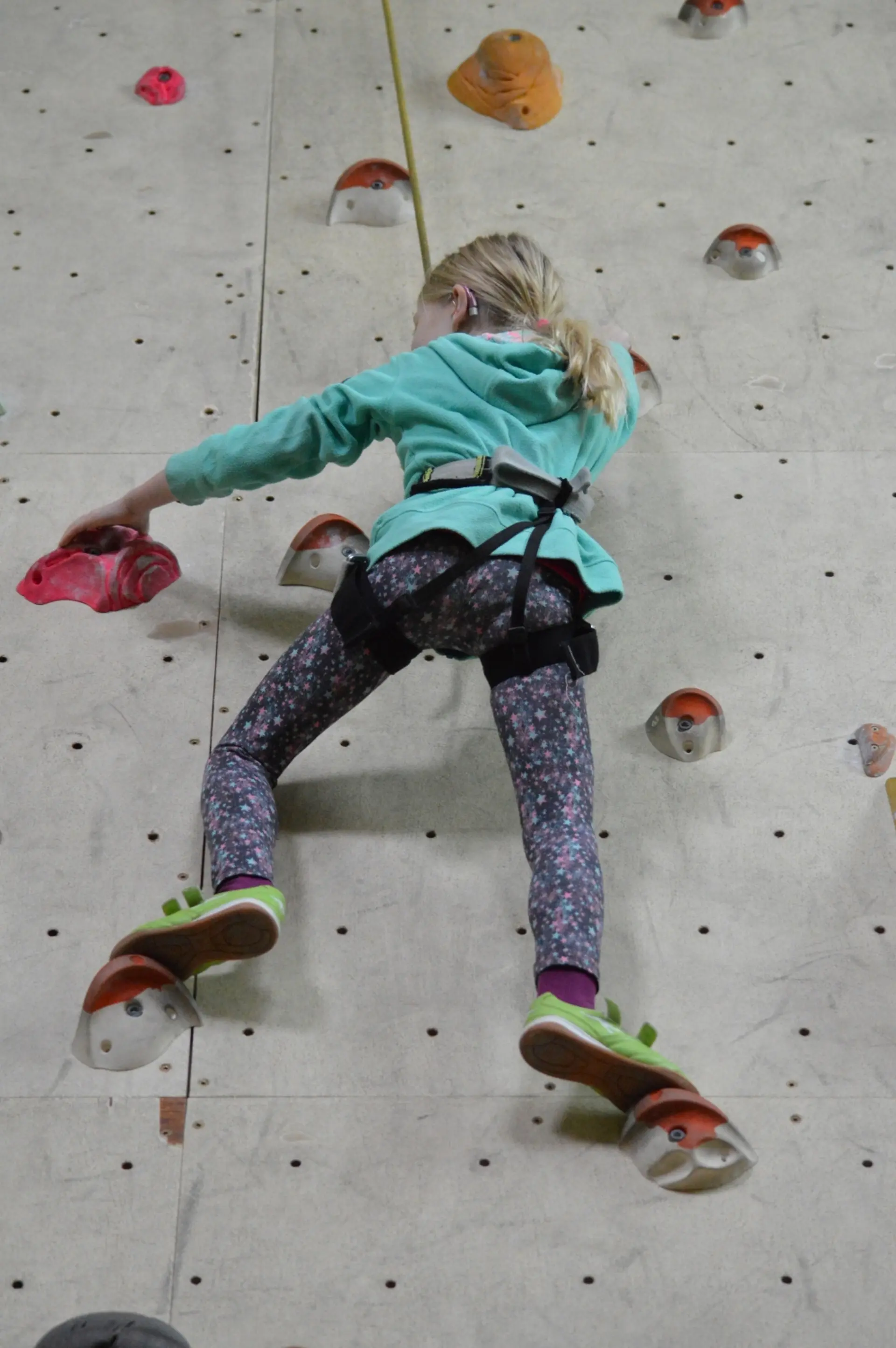 Kind beim Klettern an einer Kletterwand