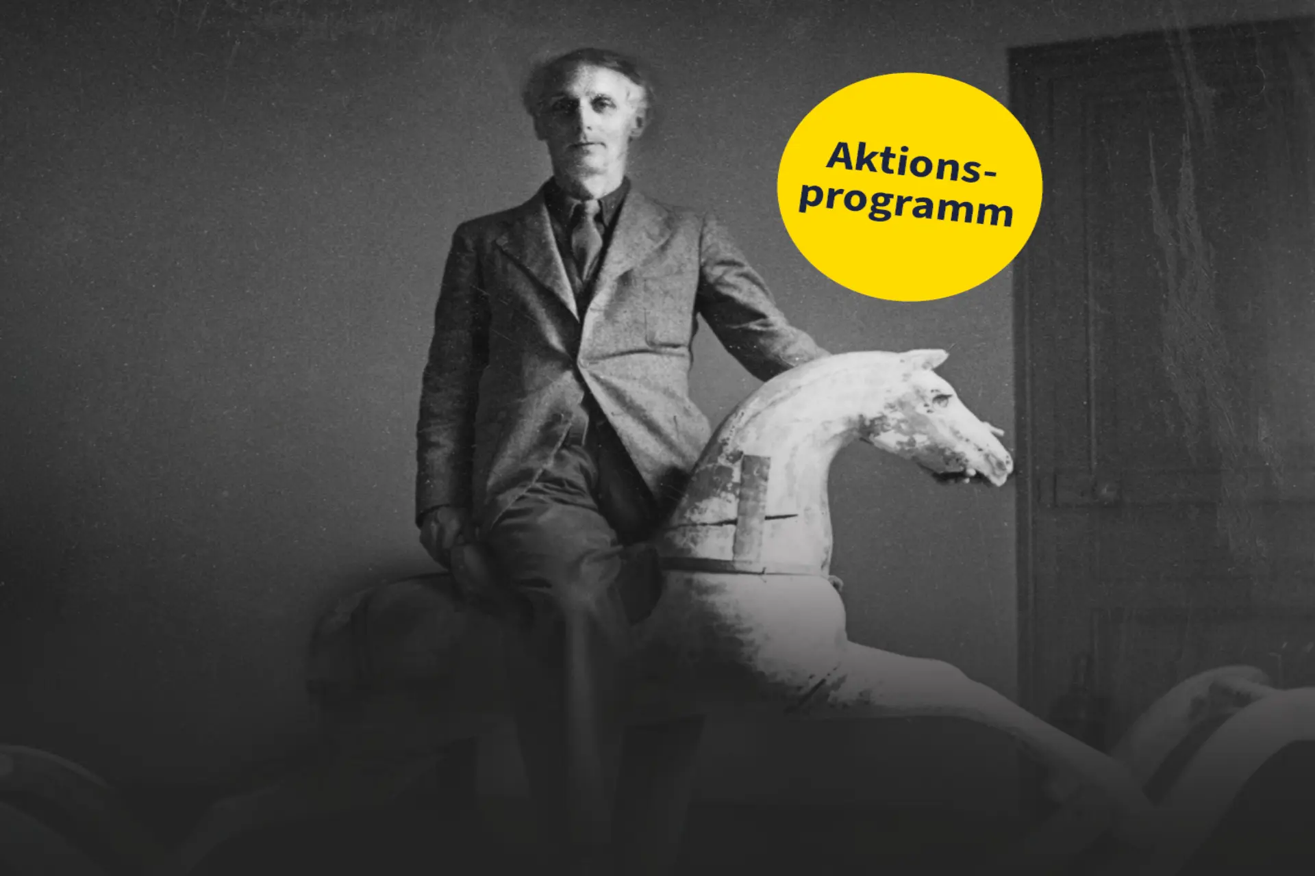 Ein schwarz-weißes Foto von Max Ernst auf einem Schaukelpferd