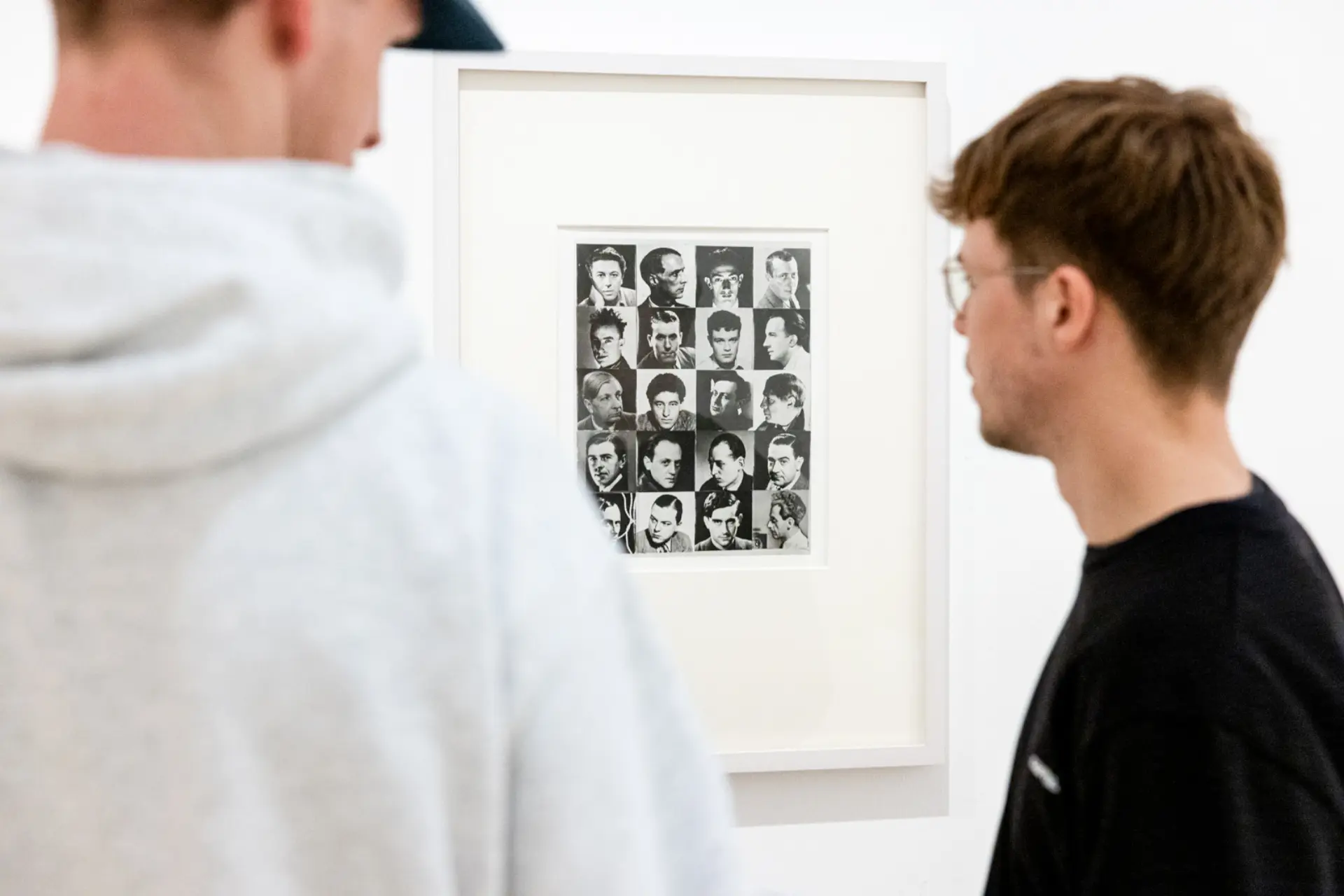 Zwei junge Männer schauen sich eine Fotografie an