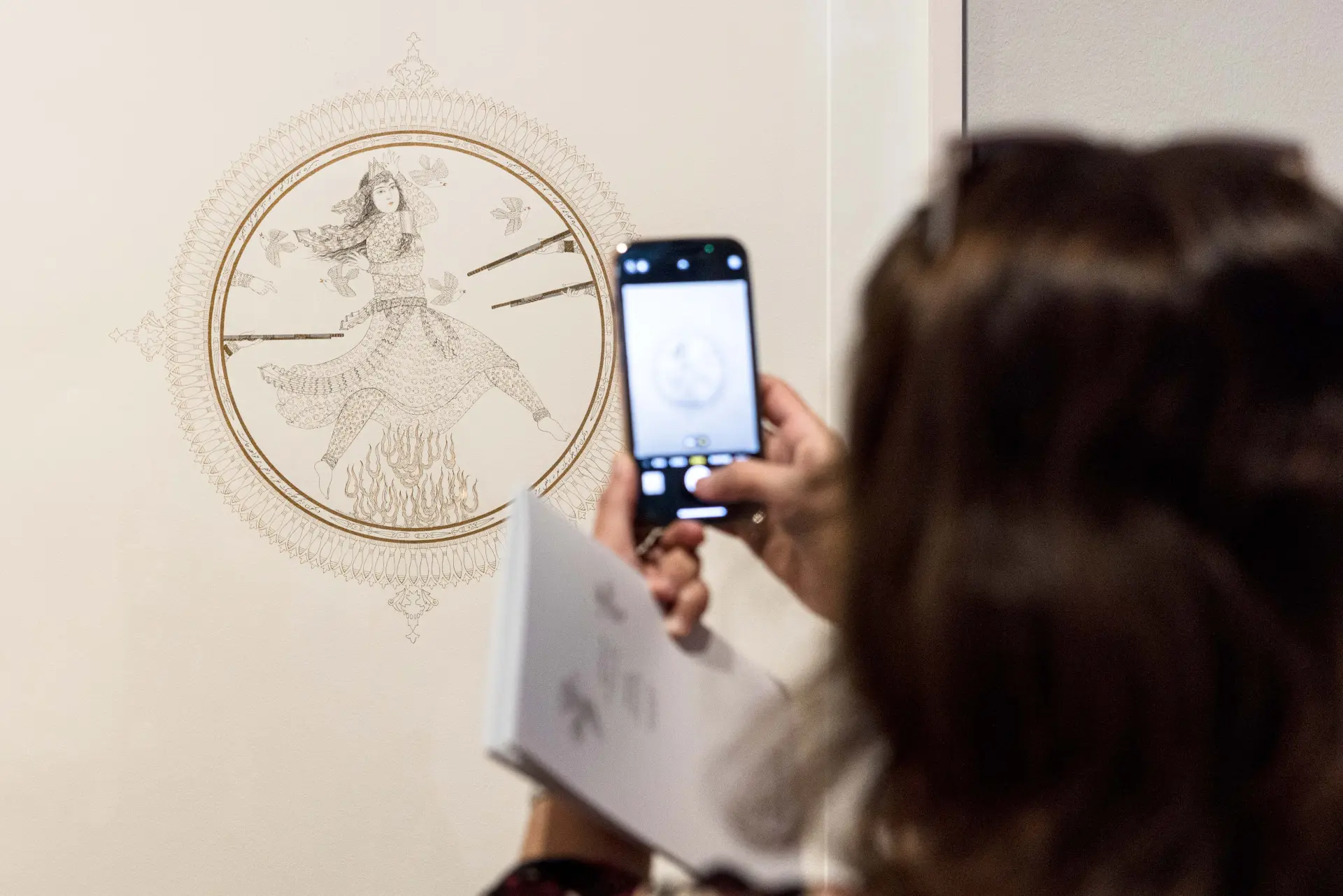 Eine Person macht ein Handyfoto von einem Werk