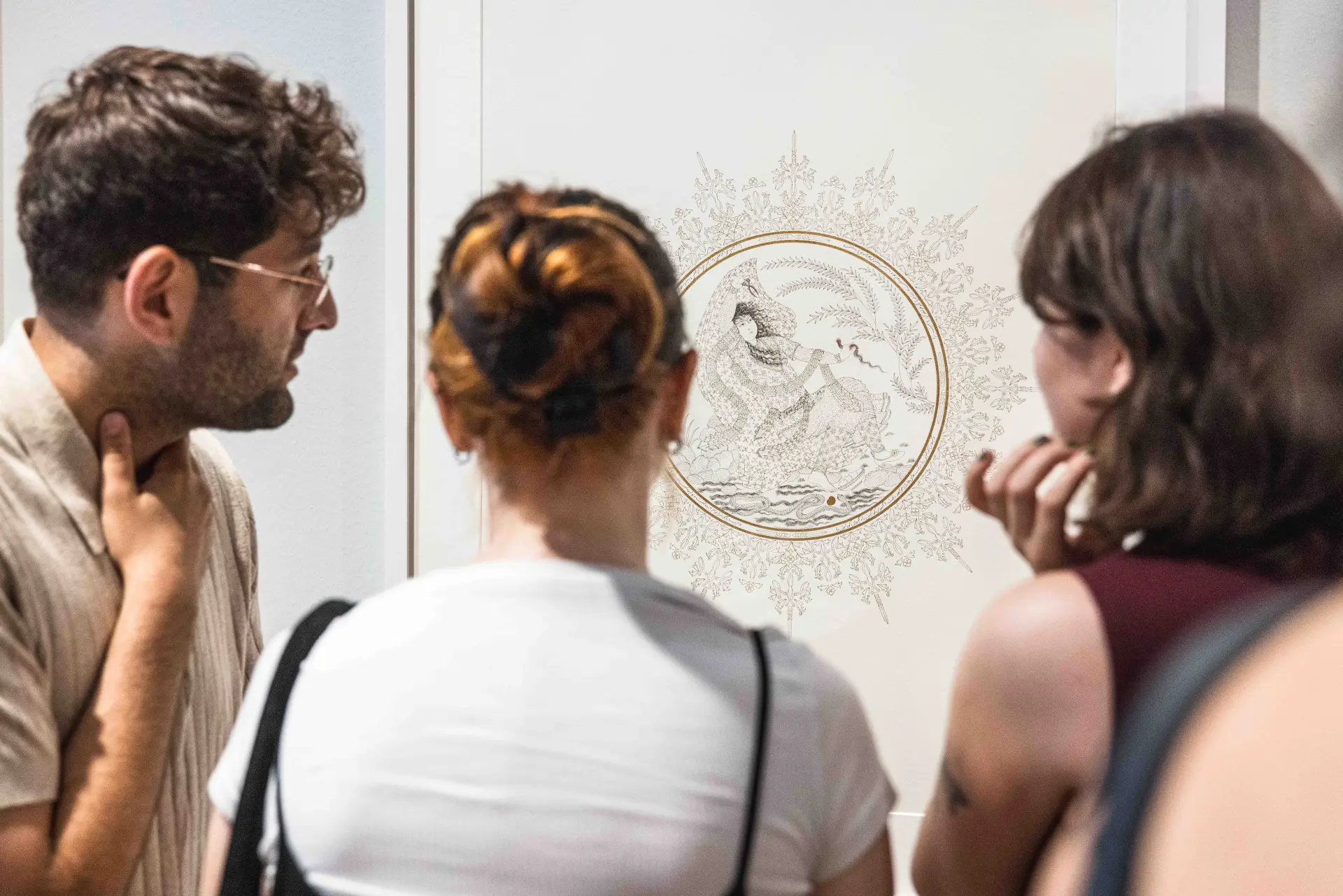 Eine Gruppe steht vor einem Kunstwerk und unterhält sich darüber