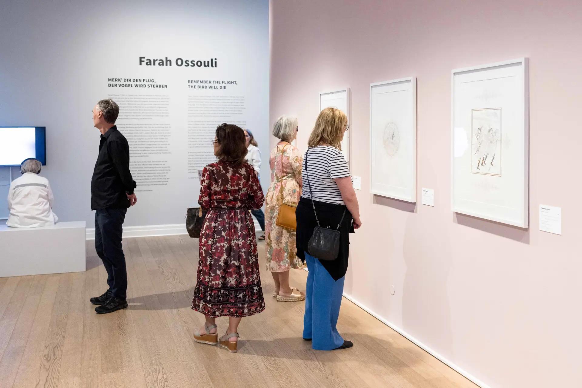 Ausstellungsbesucher*innen schauen sich Werke an