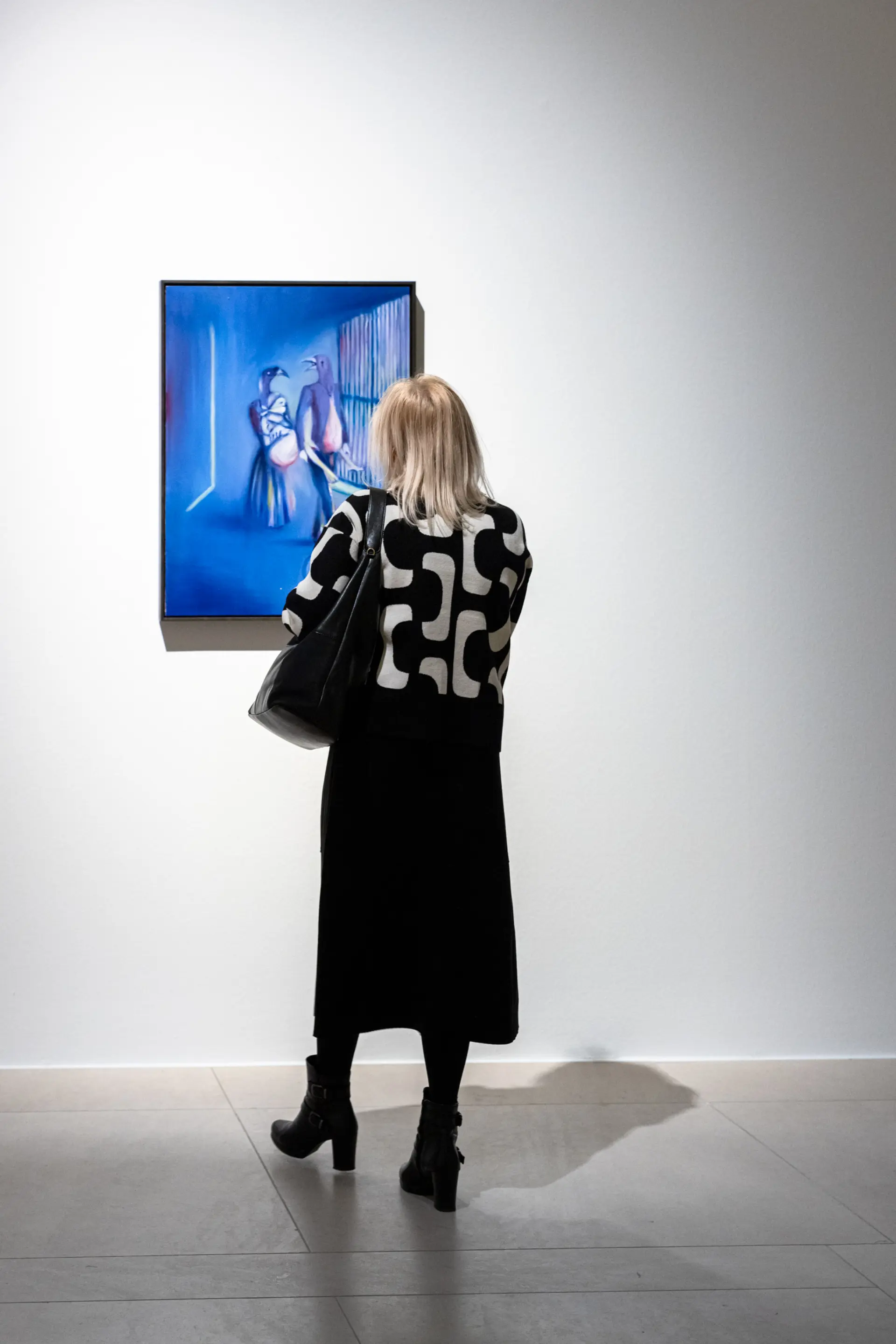 Eine Besucherin steht vor einem blauen Gemälde
