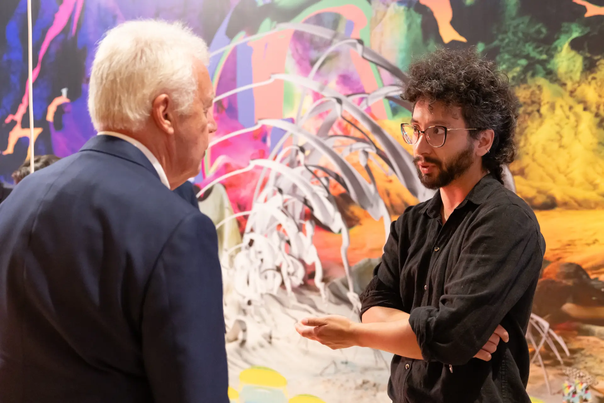 Zwei Besucher unterhalten sich vor einem Kunstwerk.